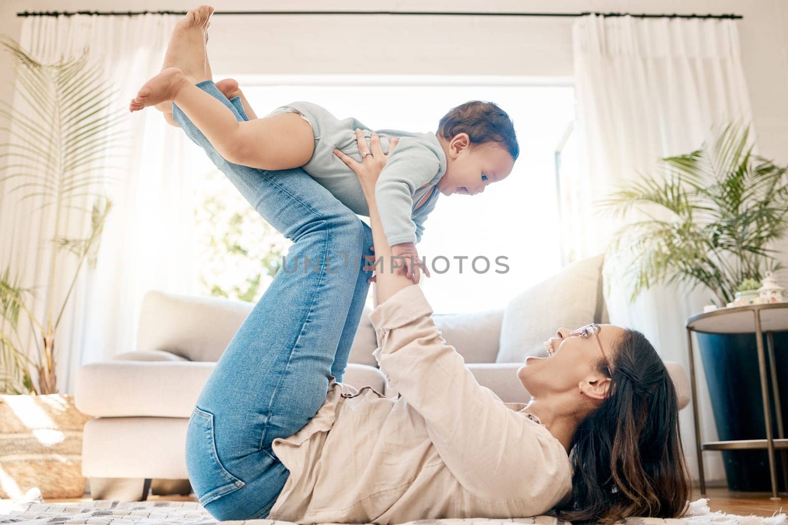 Play, love and mother lift baby for bonding, quality time and child development together in family home. New born, motherhood and happy mom with infant for care, support and playing in living room.