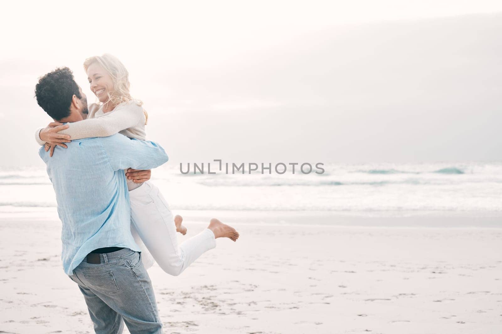 Beach, love and man carry woman on holiday, vacation and romantic weekend for anniversary. Mockup space, marriage and happy mature couple spin in air for bonding, quality time and romance by ocean.
