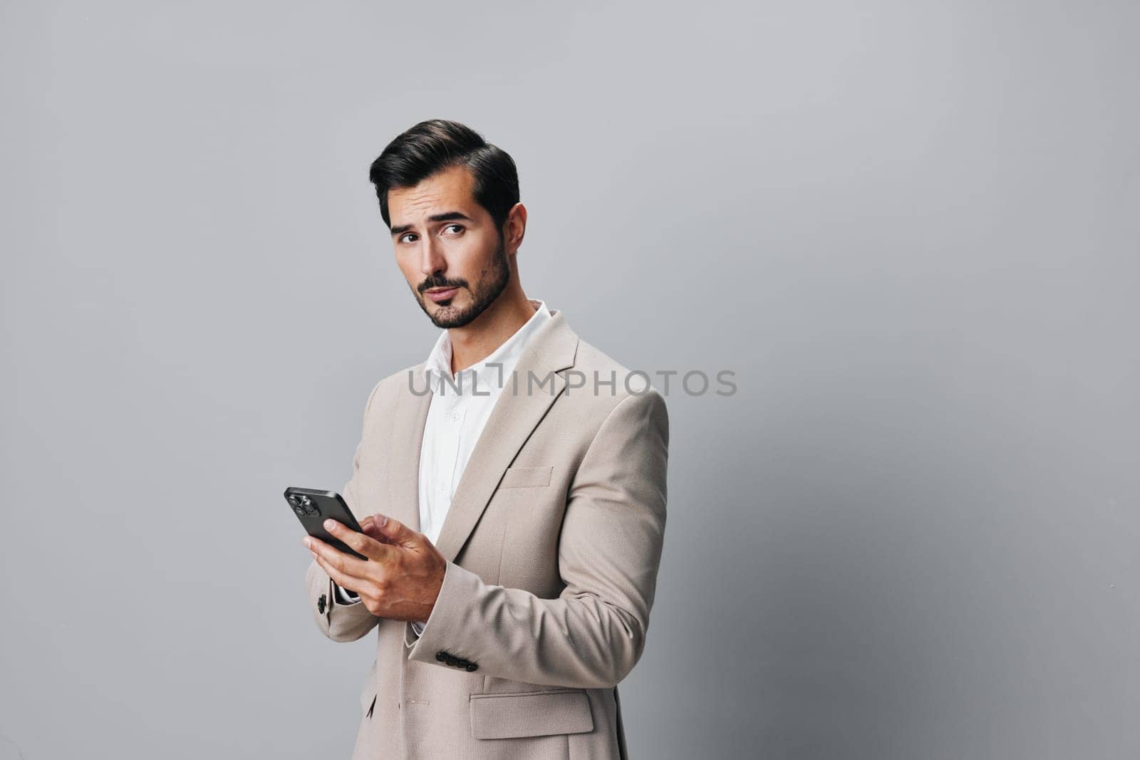 lifestyle man studio phone white suit connection hold holding business portrait space smartphone adult smile copy trading call background online businessman happy