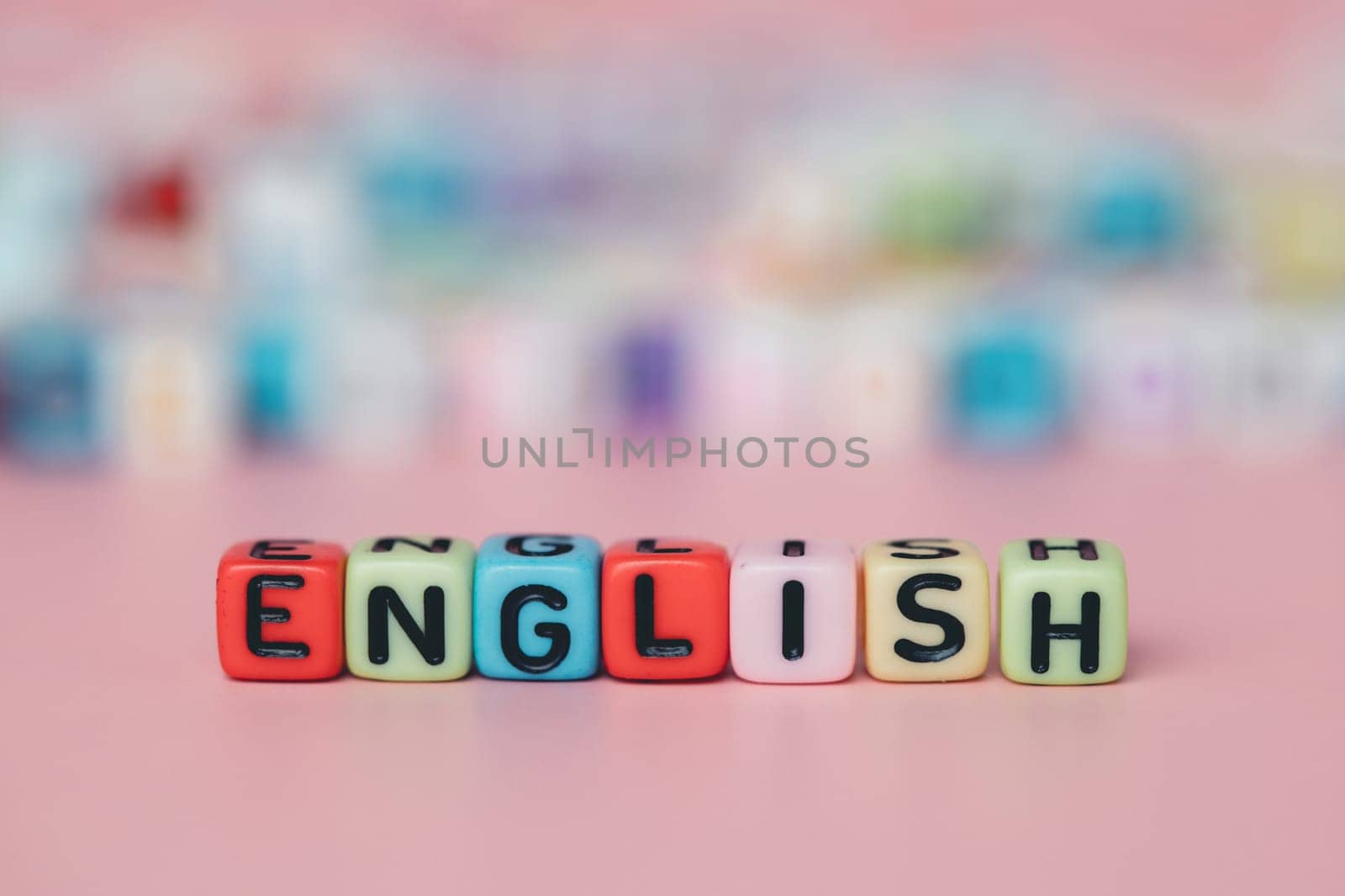 The word ENGLISH from letter beads on pink background for education and learning concept, selective focus image