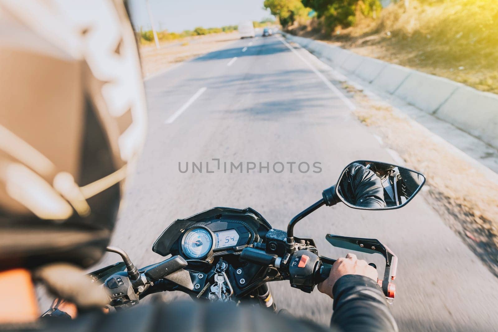 View of hands of biker driving his motorbike. Close up of motorcyclist driving his motorbike on the street by isaiphoto