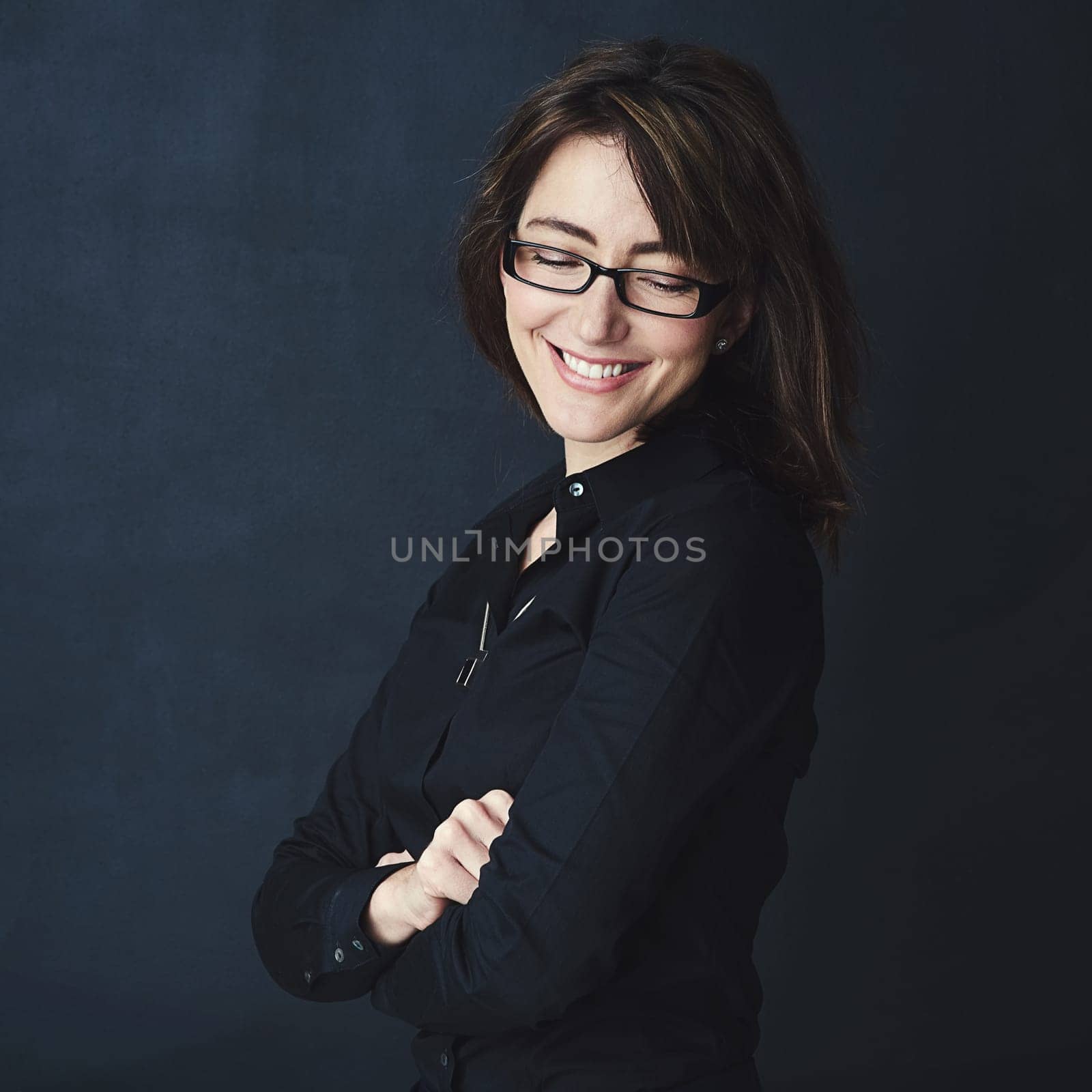 Never let your eye off your goals. Studio shot of a corporate businesswoman posing against a dark background. by YuriArcurs