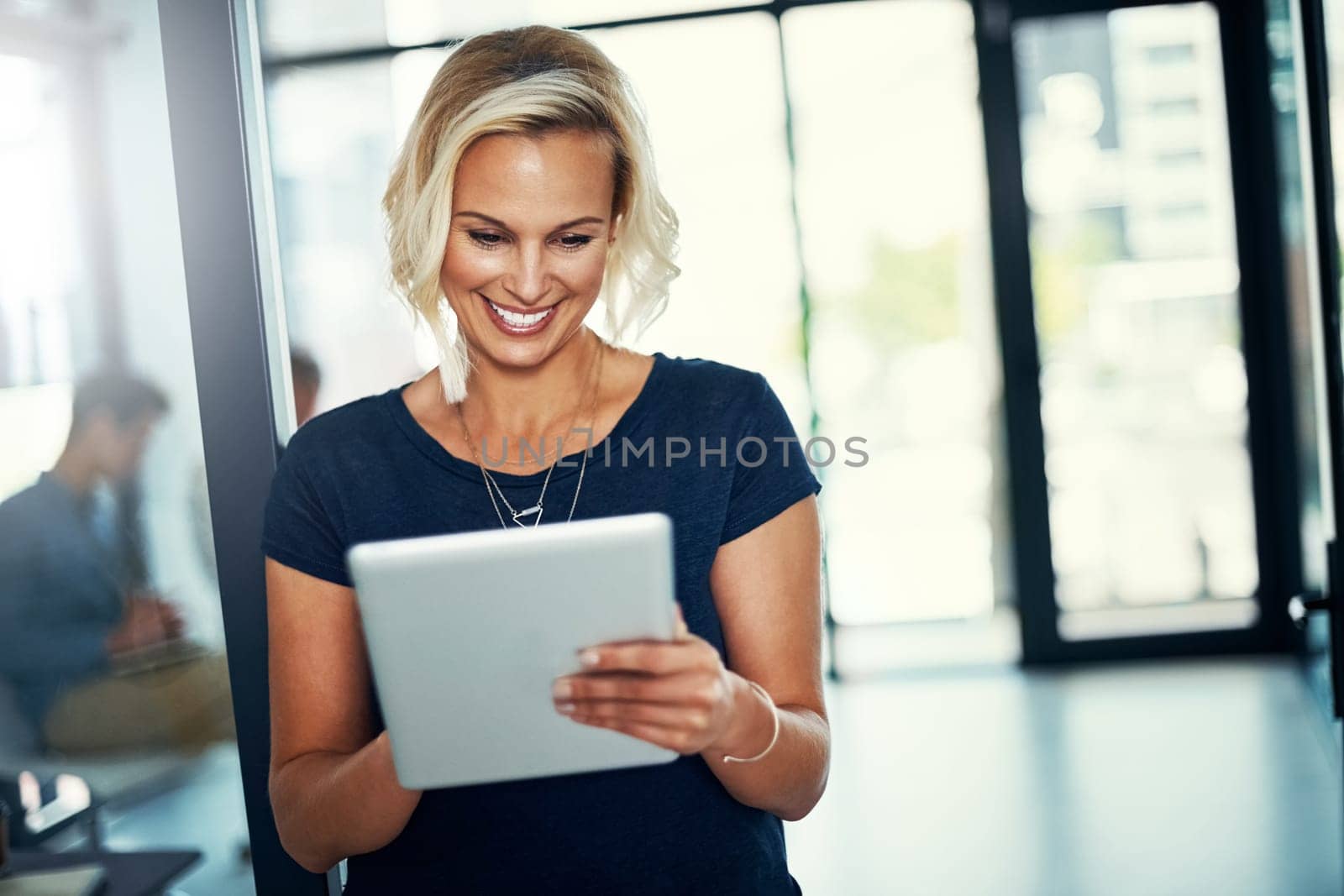 Technology that inspires something new each day. a young businesswoman using a digital tablet in an office. by YuriArcurs