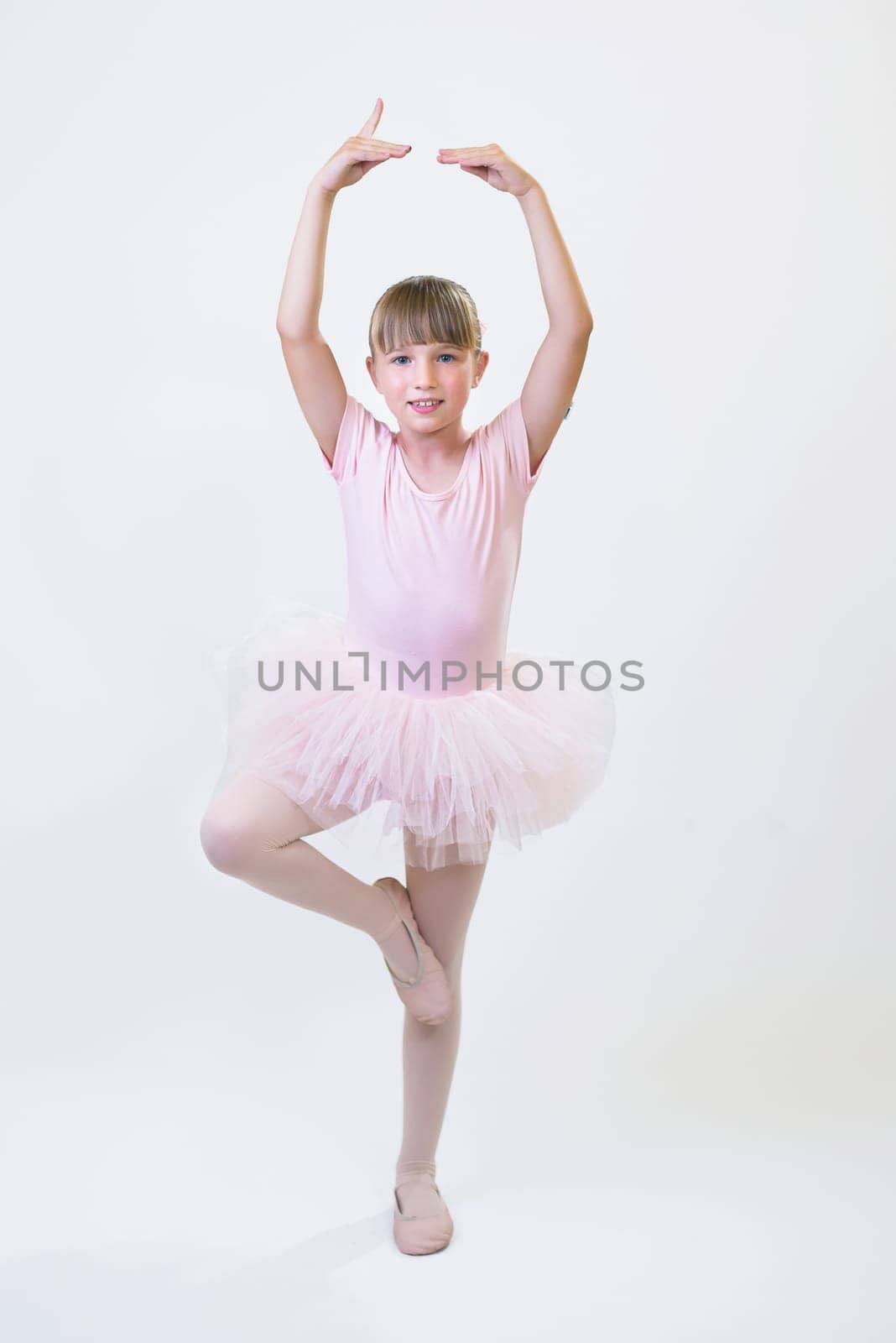 Little ballerina dancer in a pink tutu academy student posing on white background by jcdiazhidalgo