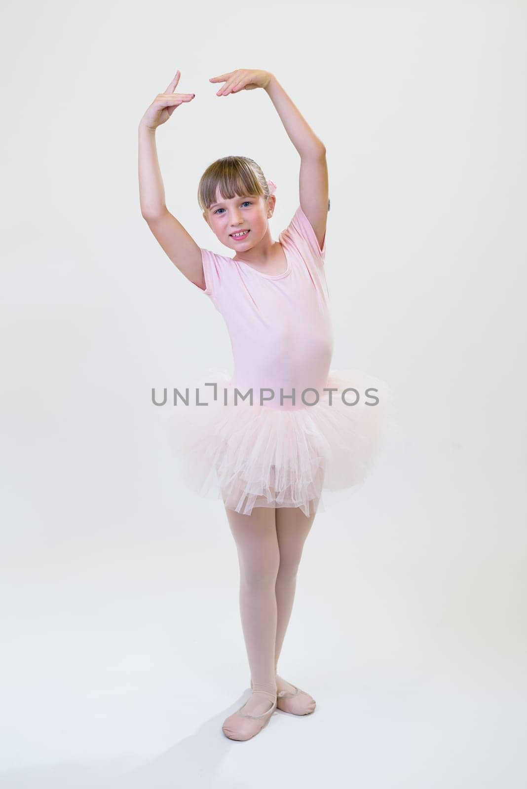 Little ballerina dancer in a pink tutu academy student posing on white background by jcdiazhidalgo
