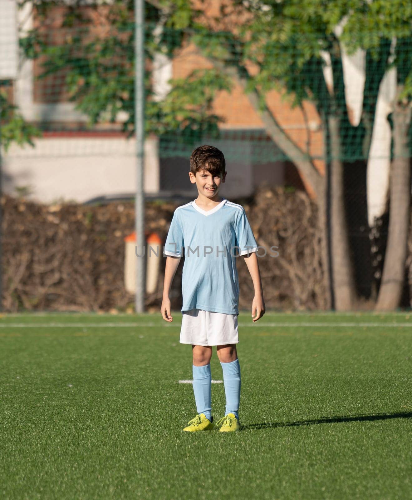 A happy young boy football player on the field.Portrait of a smiling football kid with in the soccer field.