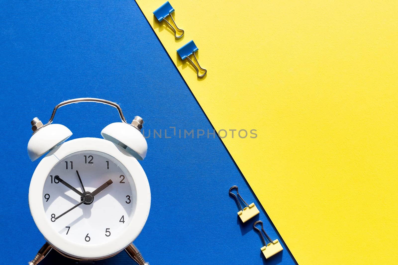 educational conceptual. books, alarm clock and stationery against green background. free copy space for your text
