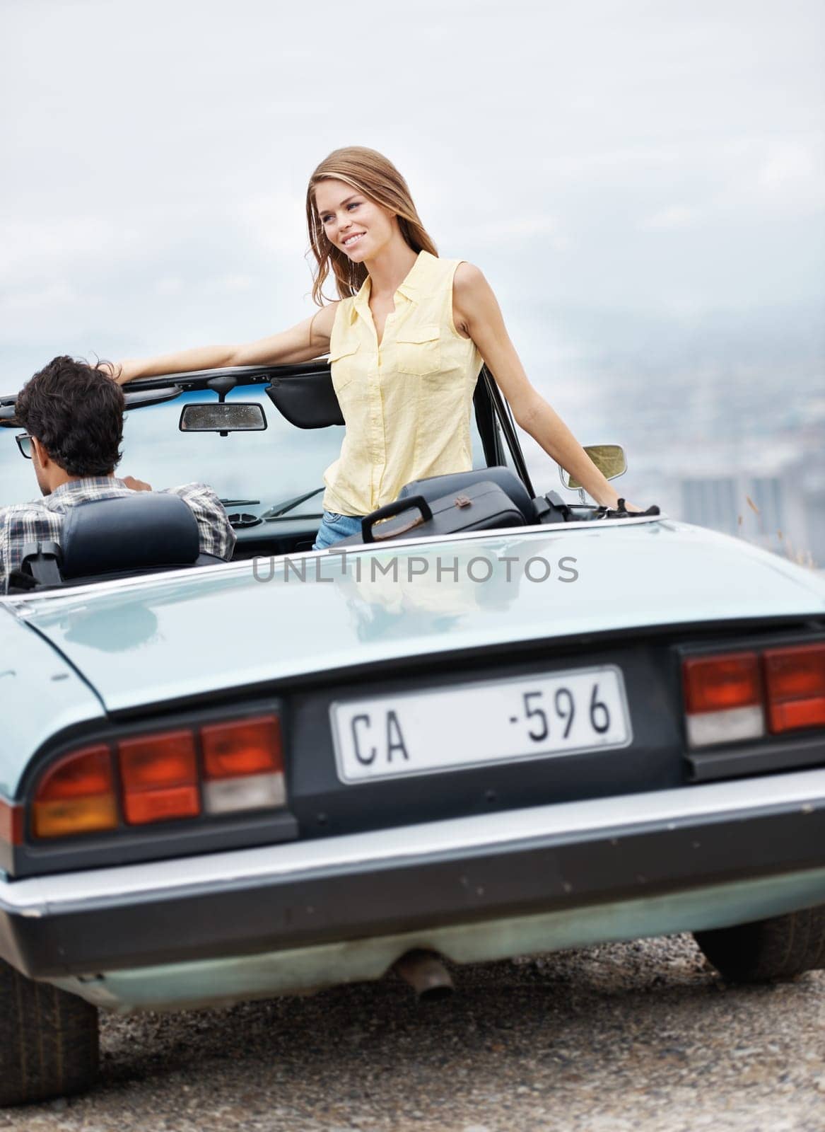 Enjoying this great view. An attractive young couple in their convertible while on a roadtrip