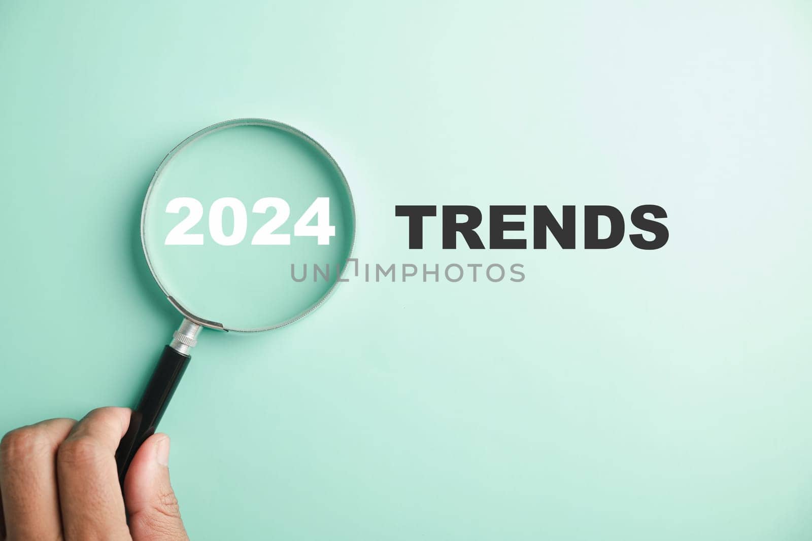 magnifier glasses reveal the words New Year 2024 Trends by Sorapop