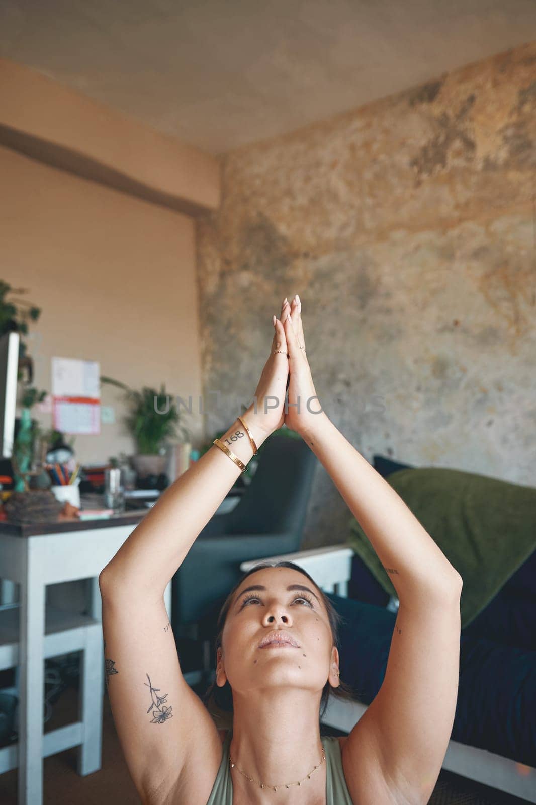 Yoga is a transformative way of life. a young woman meditating while practising yoga at home. by YuriArcurs