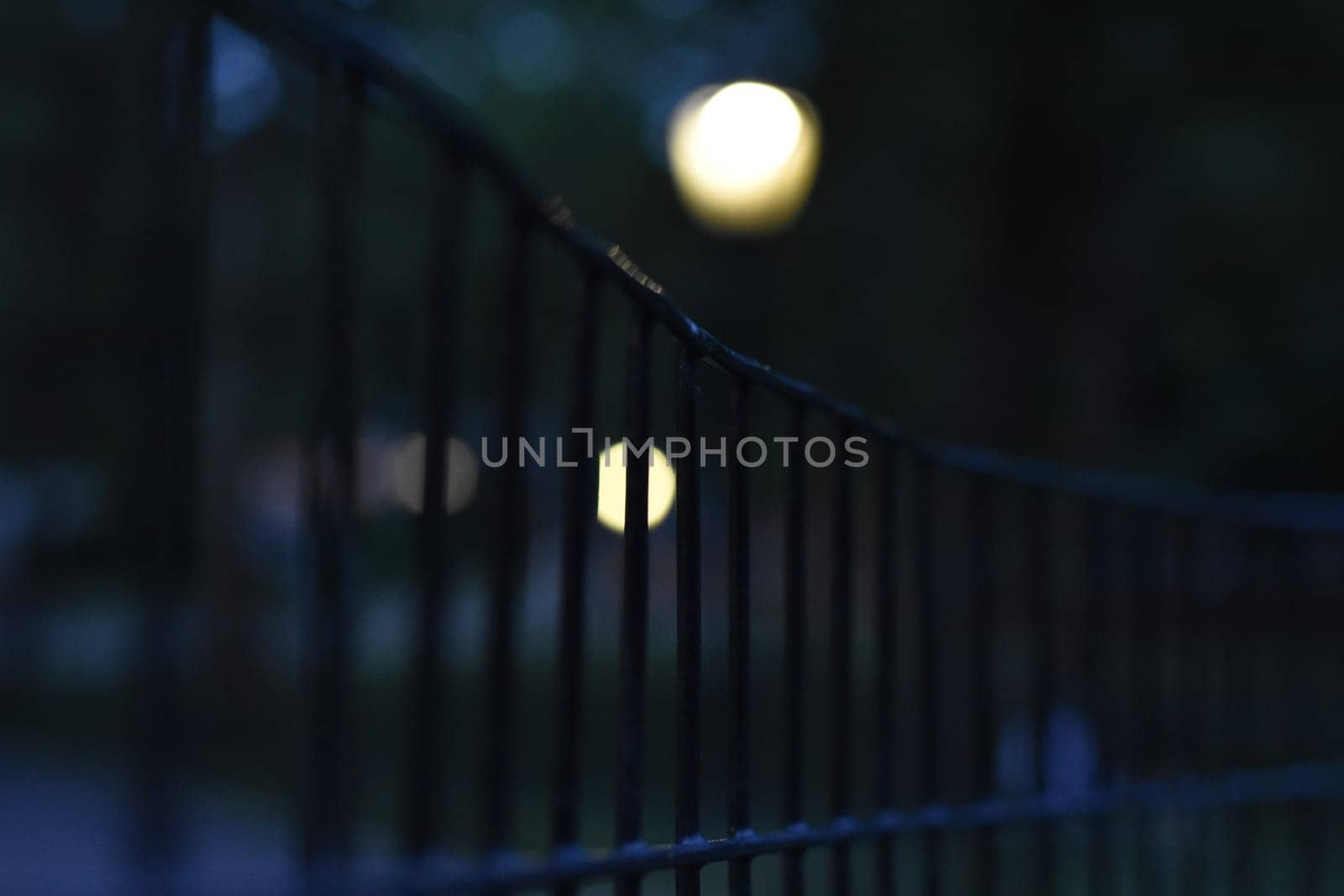 Creepy Fence in Central Park New York at Night, Lights Behind Blurred. High quality photo