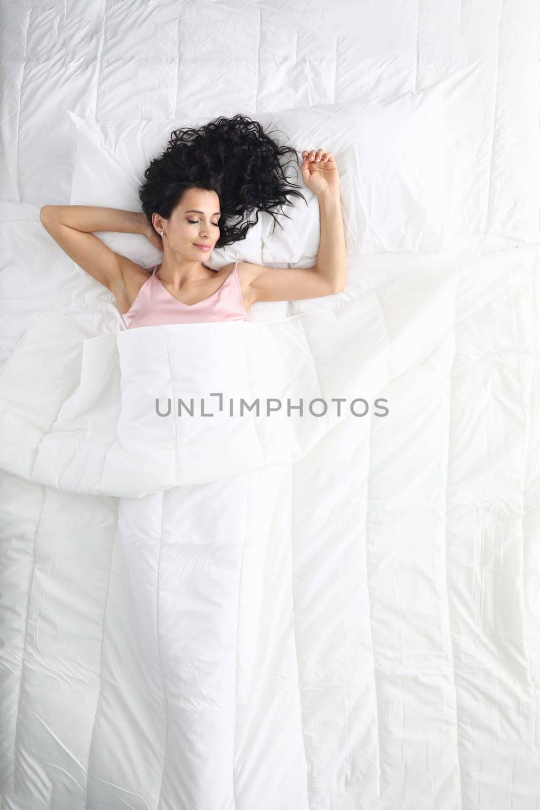 Beautiful woman sleeping serenely in bed top view by kuprevich