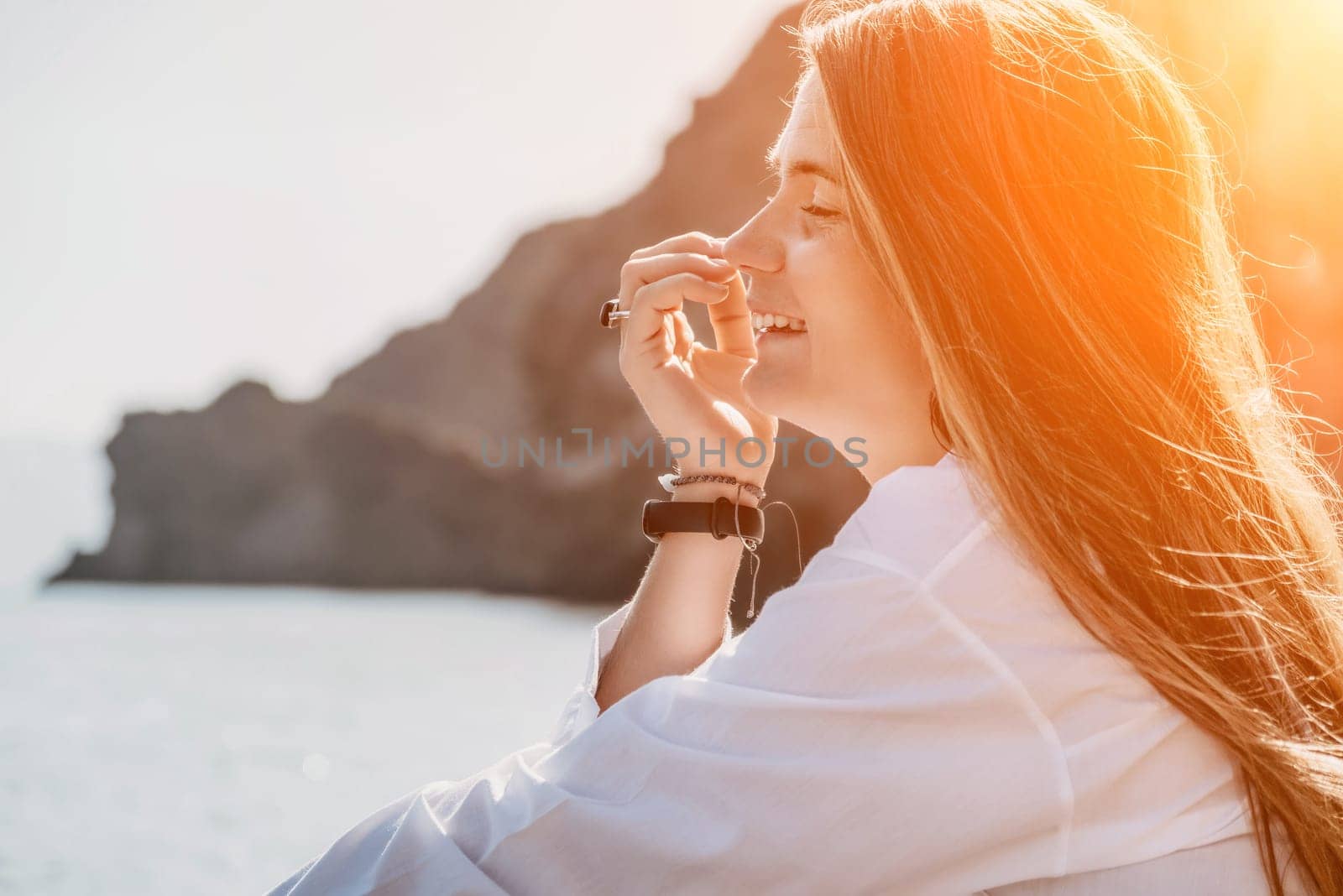 Young woman in black bikini and white shirt on Beach. Girl lying on pebble beach and enjoying sun. Happy lady in bathing suit chilling and sunbathing by turquoise sea ocean on hot summer day. Close up by panophotograph