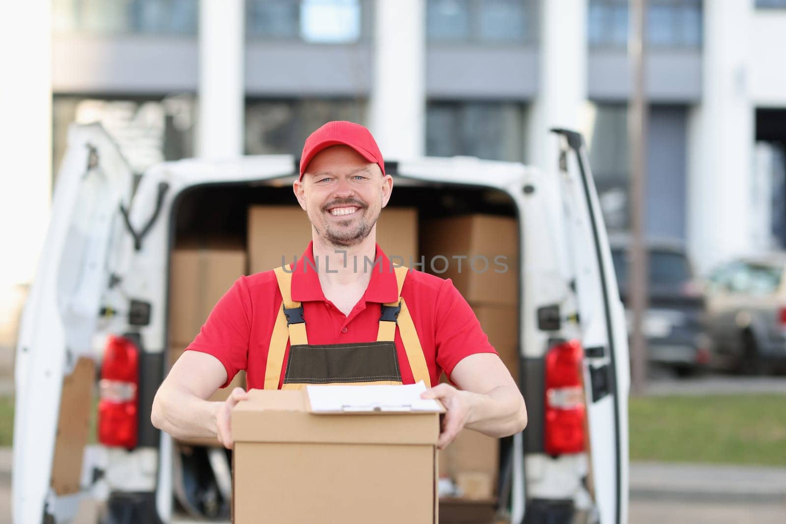Person carrying package from delivery vehicle. Courier service and logistics concept