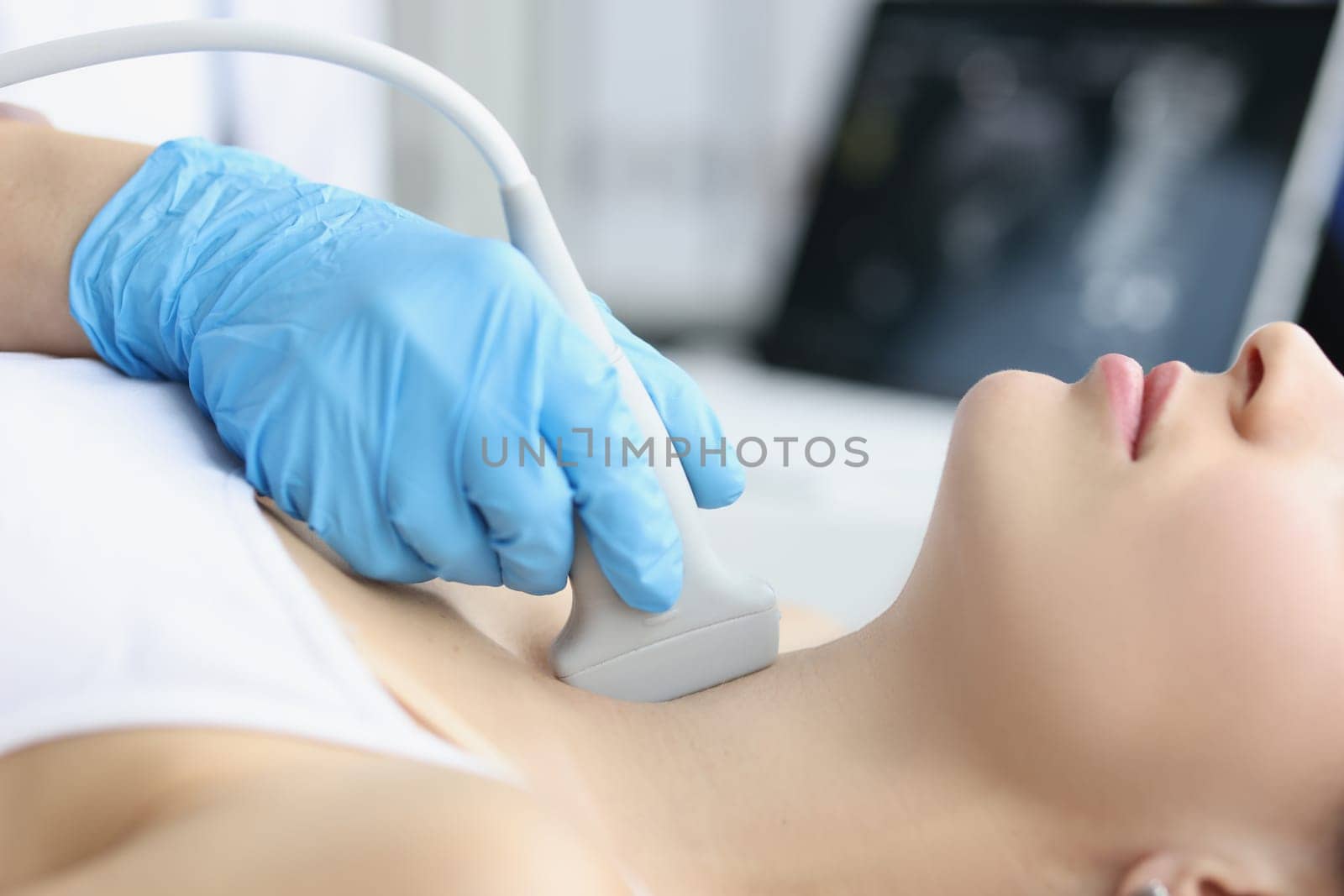 Adult woman undergoes ultrasound of thyroid gland in office of female doctor by kuprevich