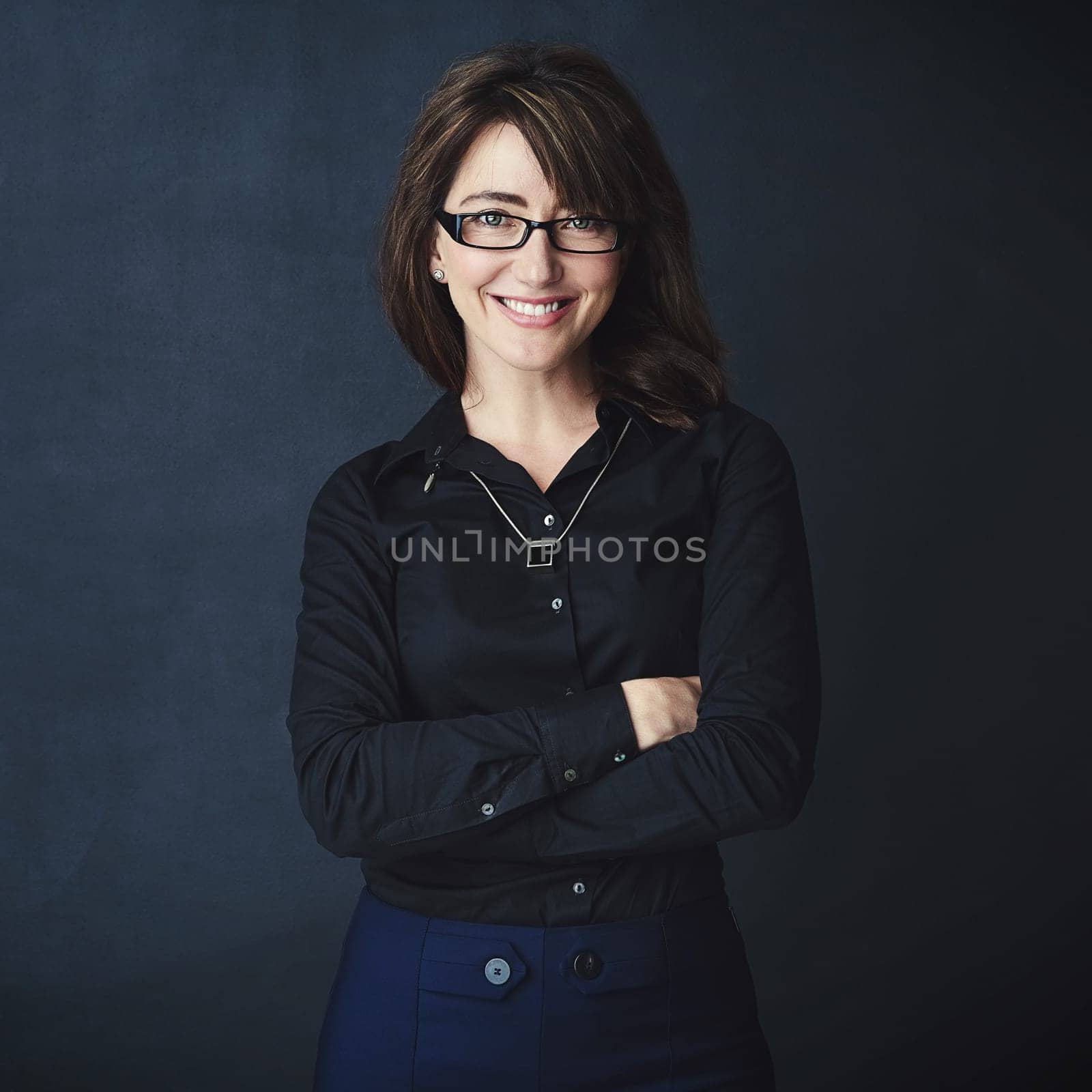 Success stems from confidence. Studio portrait of a corporate businesswoman posing against a dark background. by YuriArcurs