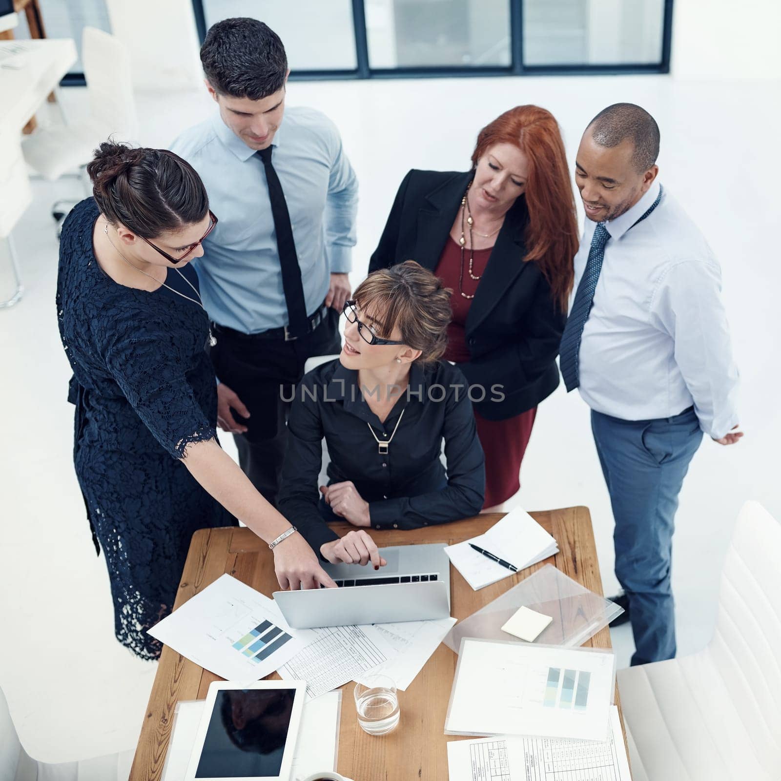 Letting technology drive their business processes and functions. group of businesspeople using a laptop together during a meeting in an office