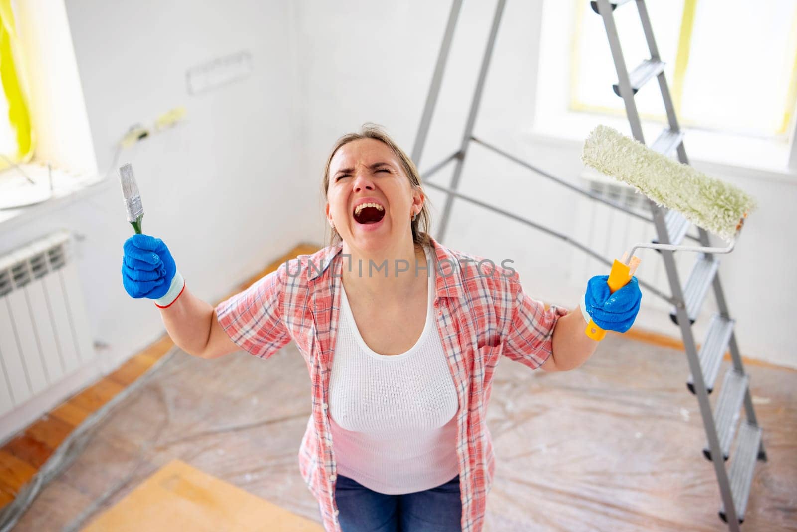 Tired, exhausted, stressed woman doing a home renovation. A woman faces many problems and difficulties in repairing