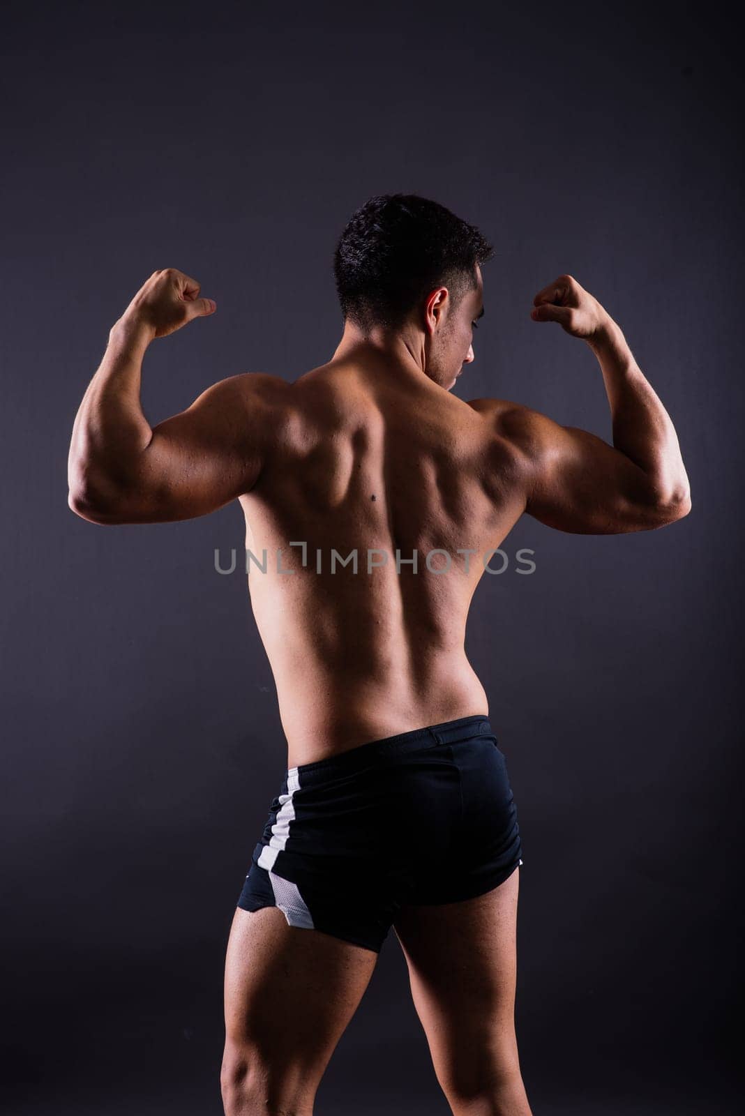 Muscular shirtless young man standing confident, front view, looking at camera by Zelenin