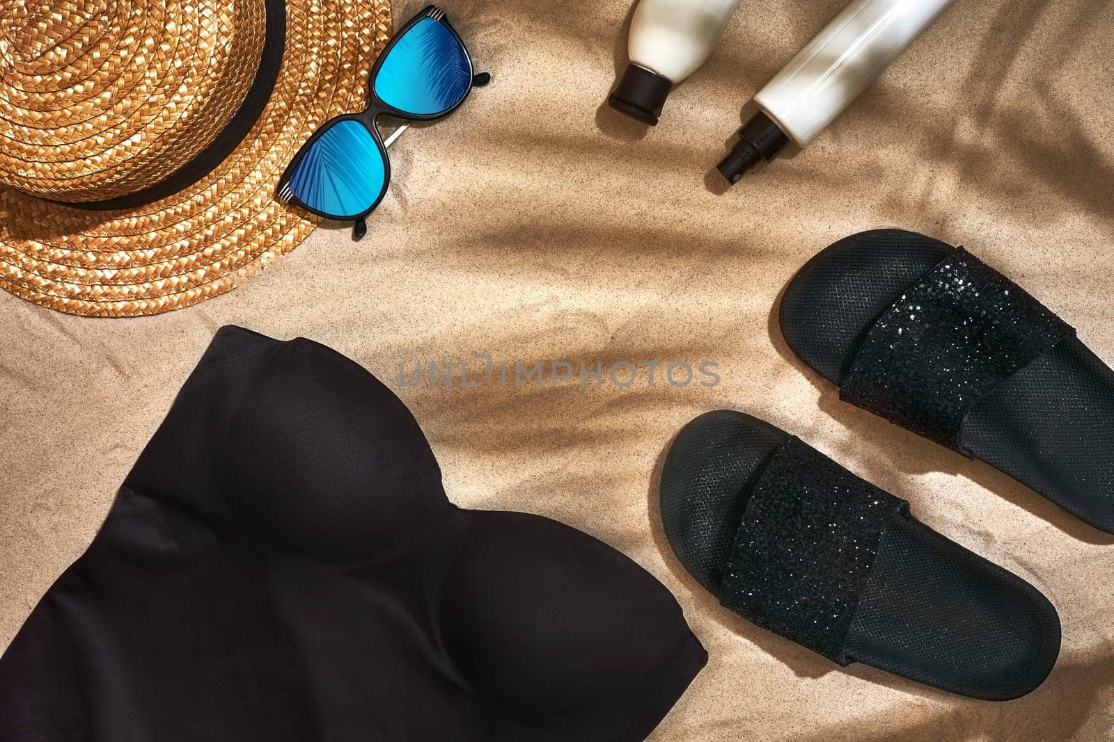 Summer background with straw hat, sunglasses, sunscreen bottle and flip flops. Top view. Still life. Copy space. flat lay