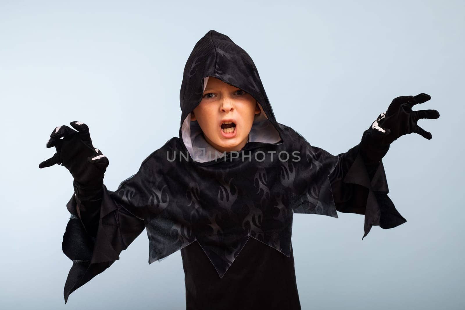 Happy Halloween. Portrait of an angry little boy in halloween costume with frightening gesture.