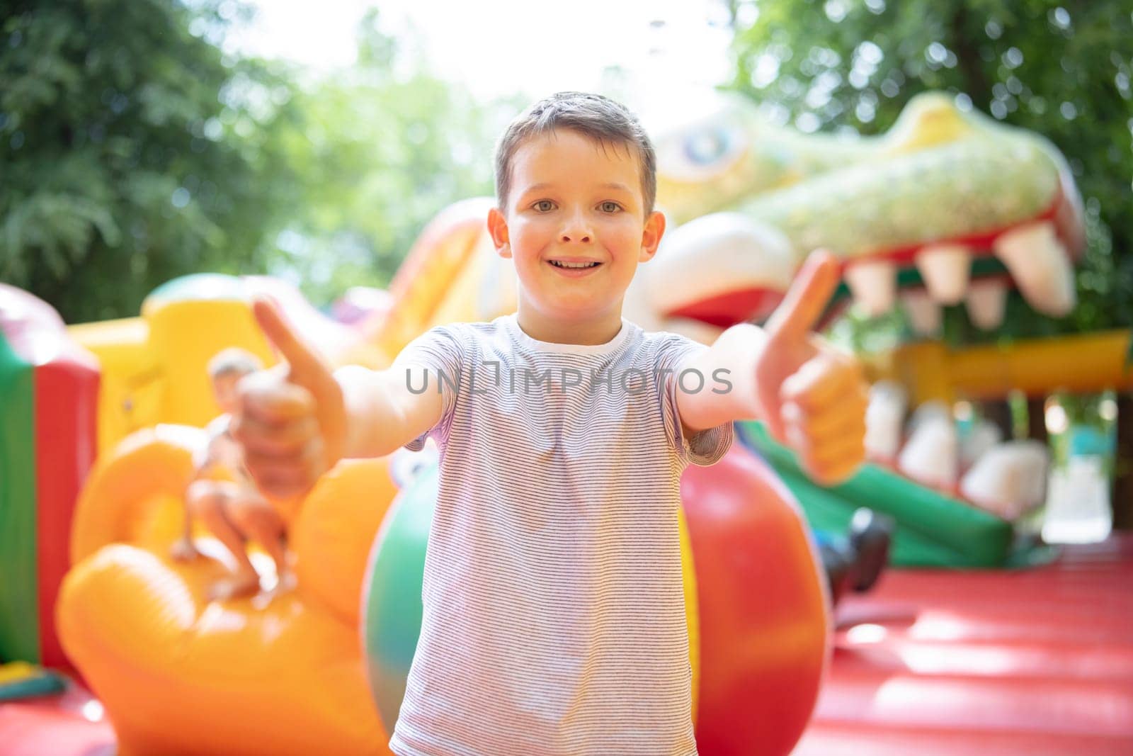 Happy boy having a lots of fun on a colorful inflate castle. Colorful playground. Activity and play center for kids.