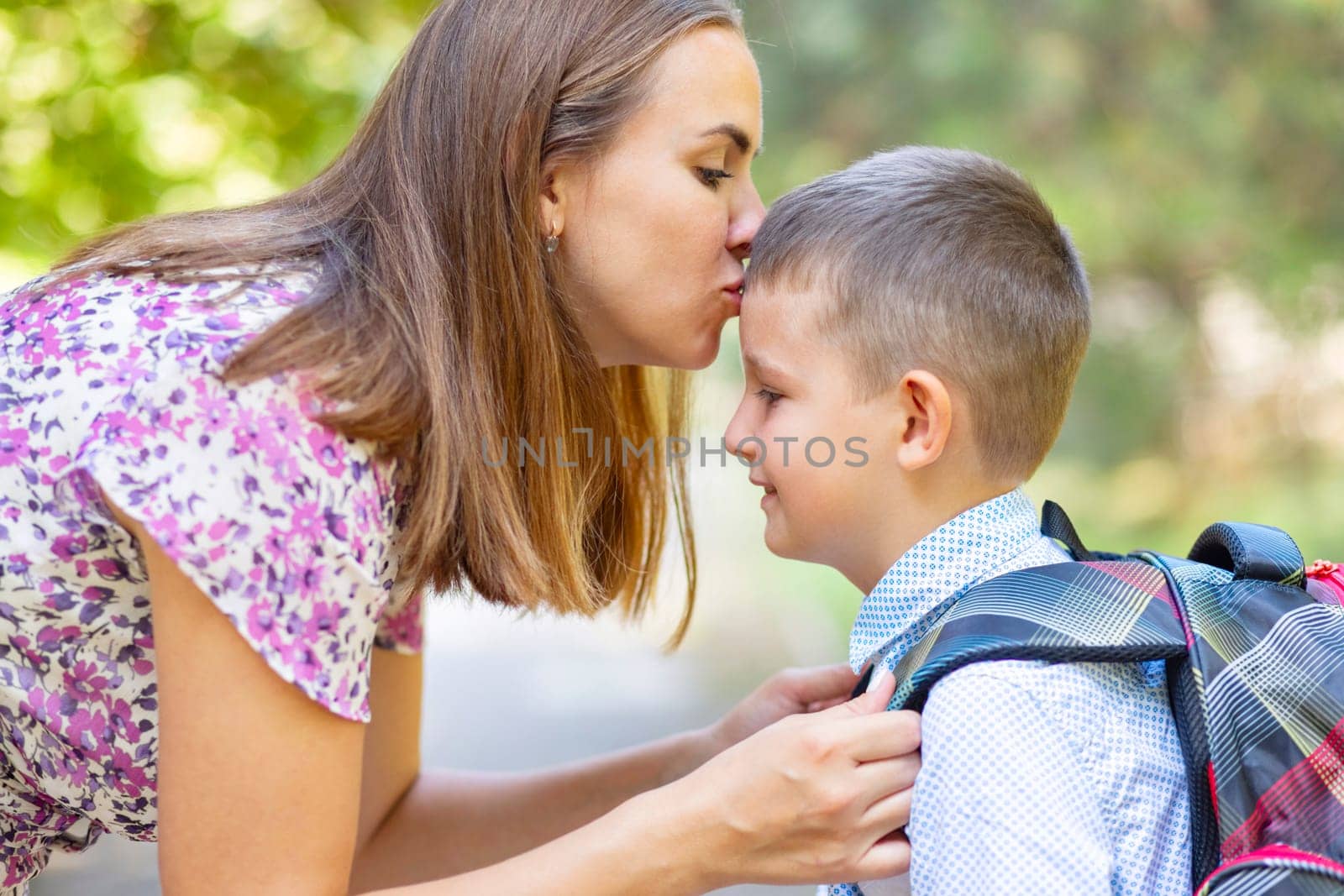 Back to school. Mother saying goodbye to her son as he leave for School. Schoolboy is ready go to school. First day at school.