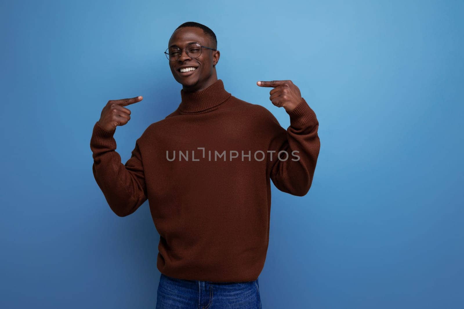 portrait of a successful young african man of model appearance in a brown sweater isolated with copy space background.