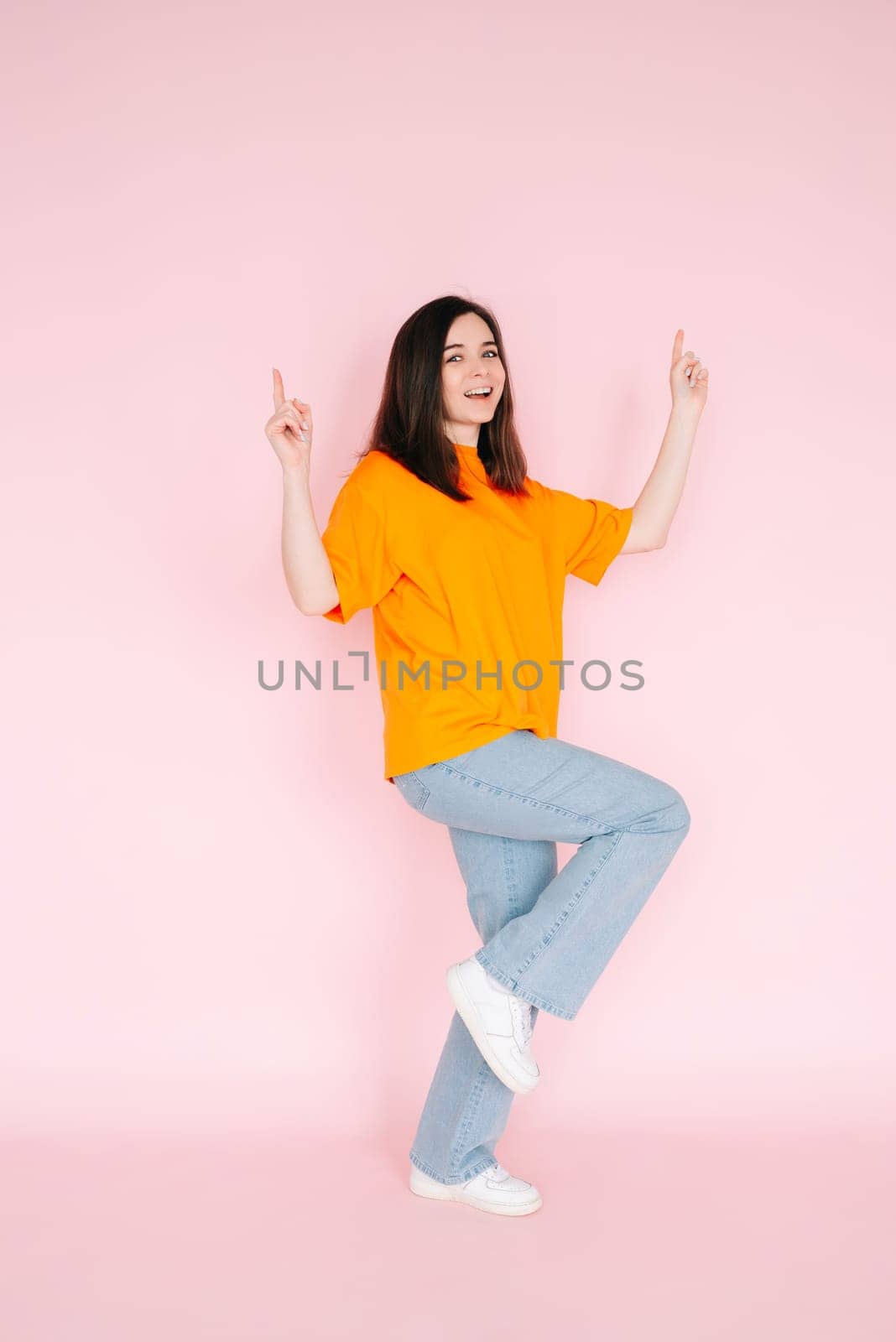 Triumphant Achievement: Beautiful Young Woman Celebrating Contract Success with Raised Fists, Commemorating a Major Sales Promotion - Vibrant Pink Background.