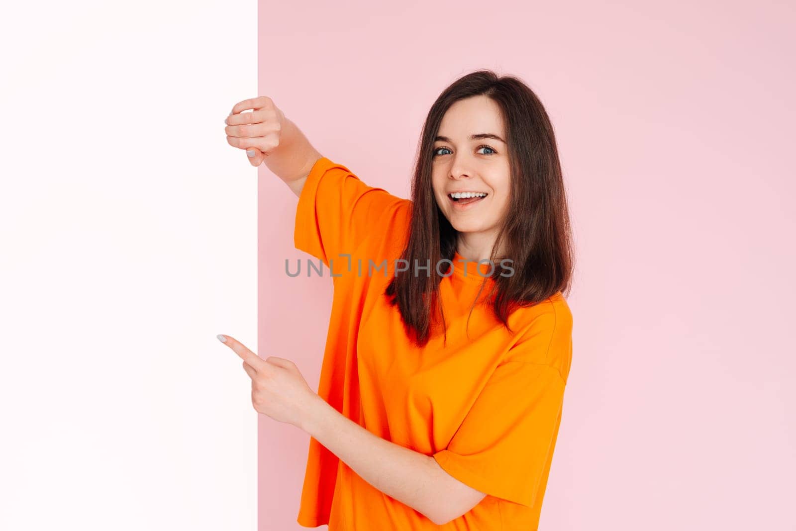 Bargain Hunter: Optimistic Girl Holding Paper Board with Empty Space - Affordable Prices Presentation for Advertising, Isolated on Pink Background