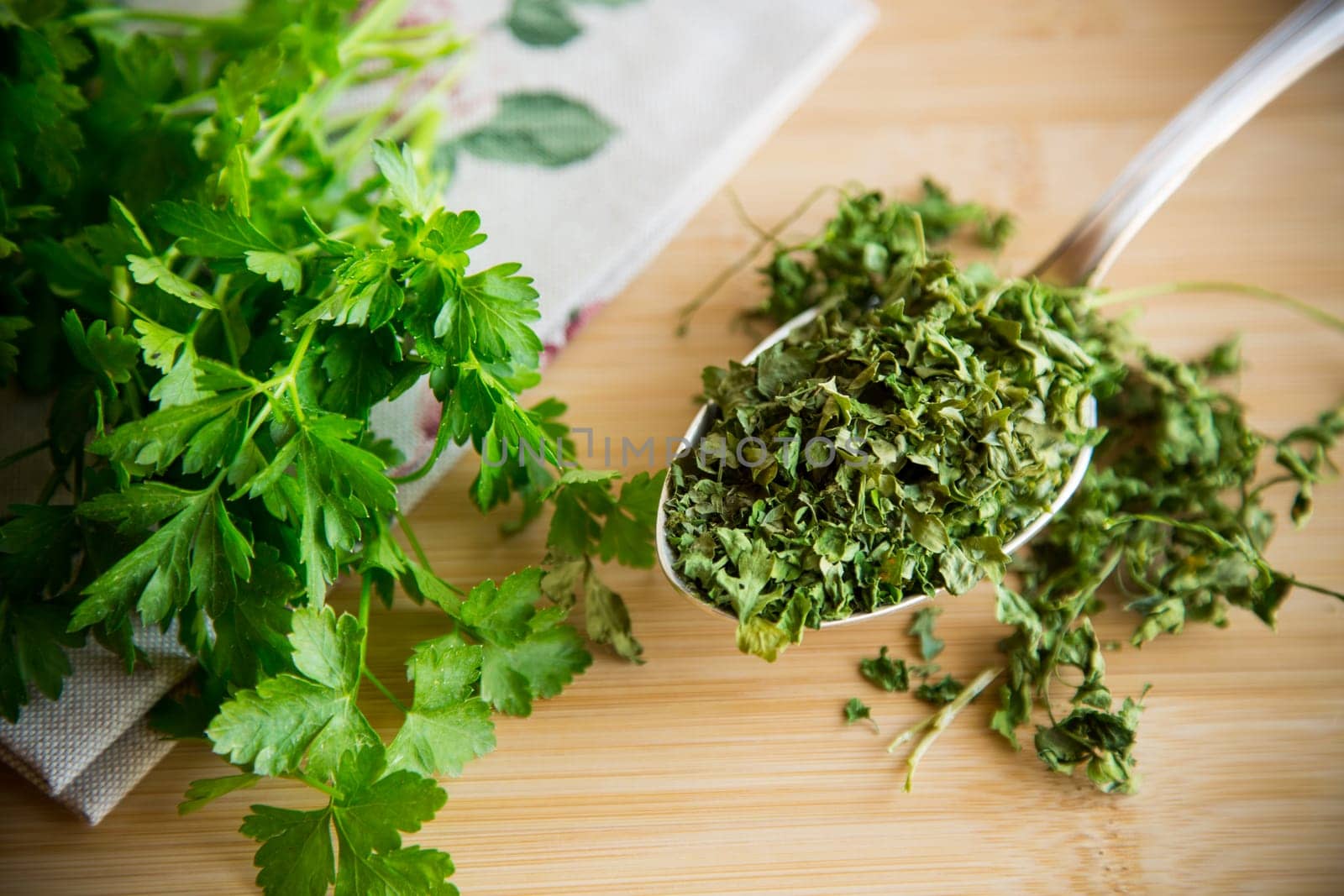 dried parsley in a spoon next to fresh herbs. by Rawlik