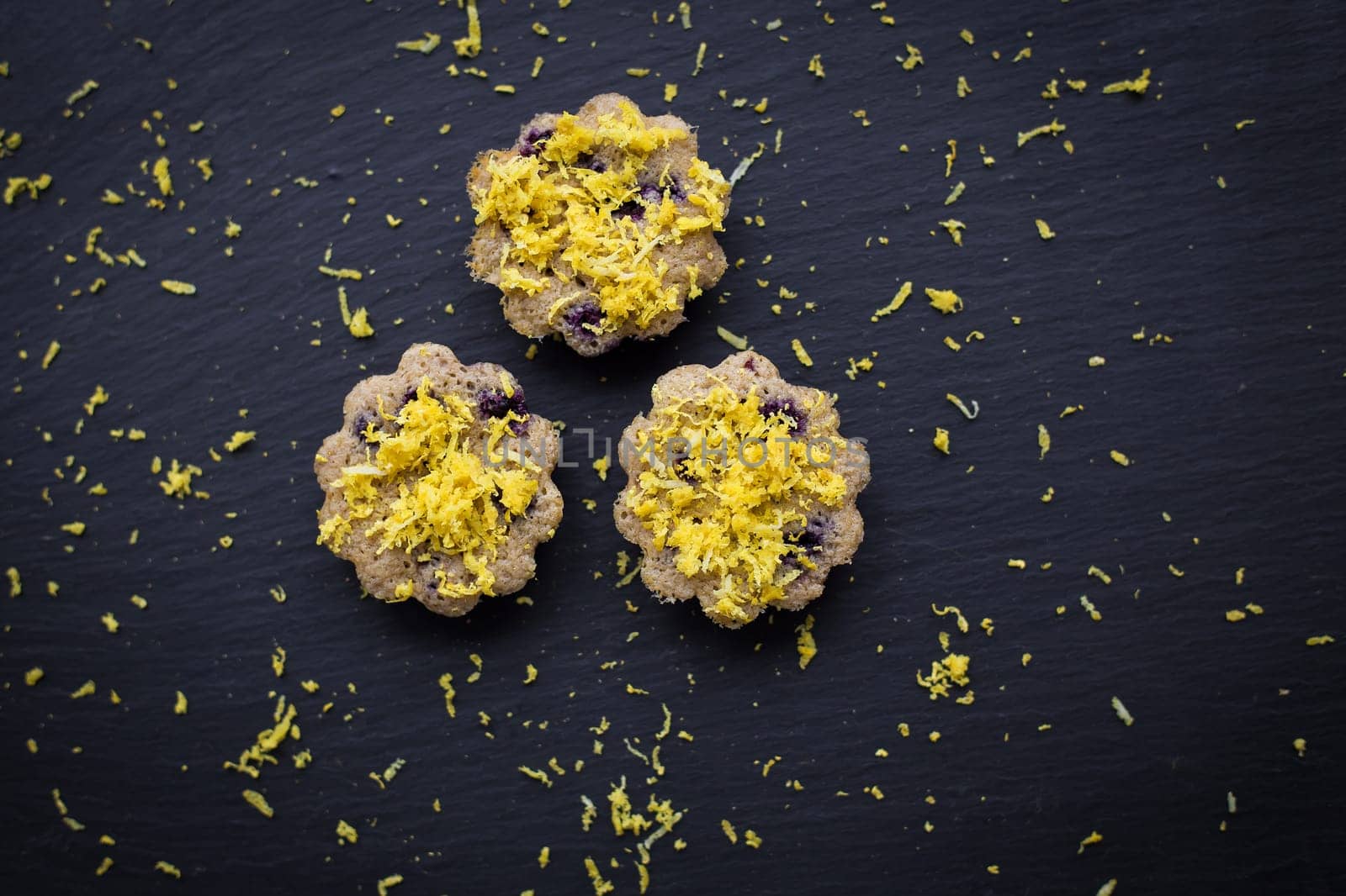 Three lemon cupcakes on a black background