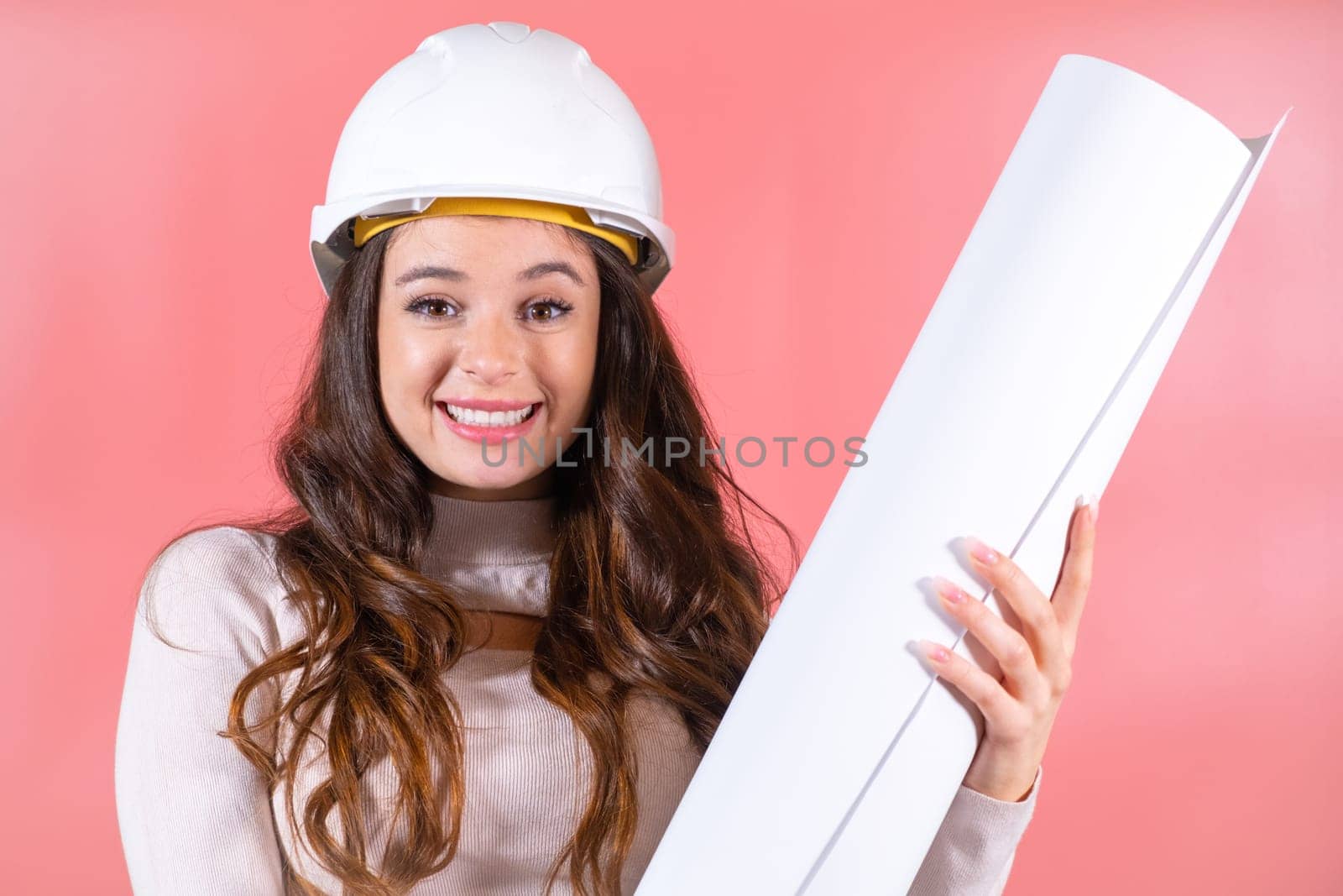 Wearing a white hardhat, a smiling woman architect embraces her job with a delighted expression, finding joy in her work.