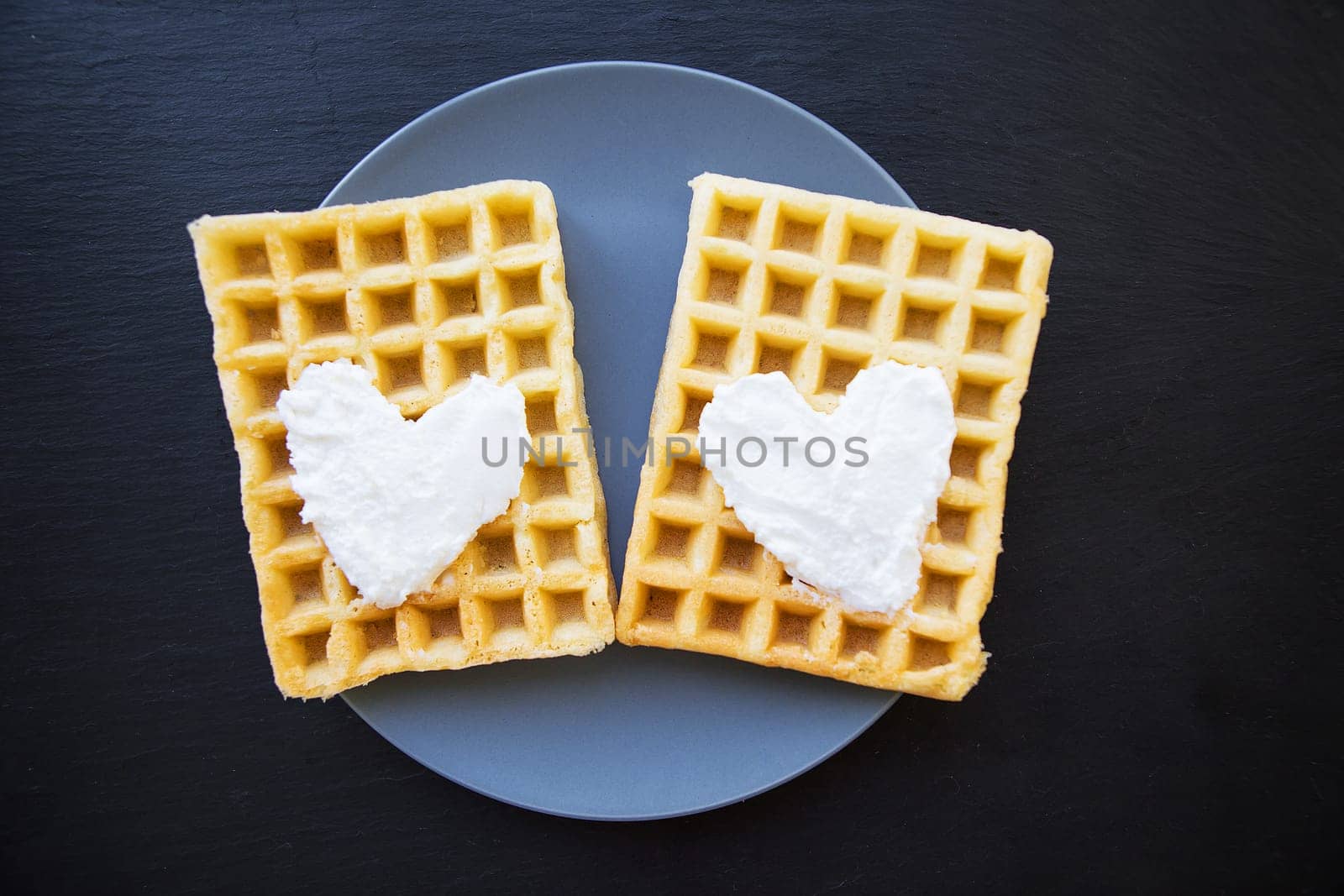 Delicious belgian waffles with cream on a black background