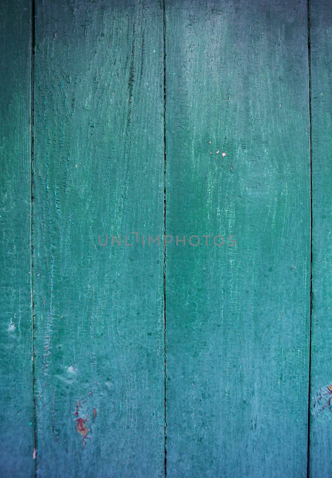 Shabby and very old green-blue wooden fence.