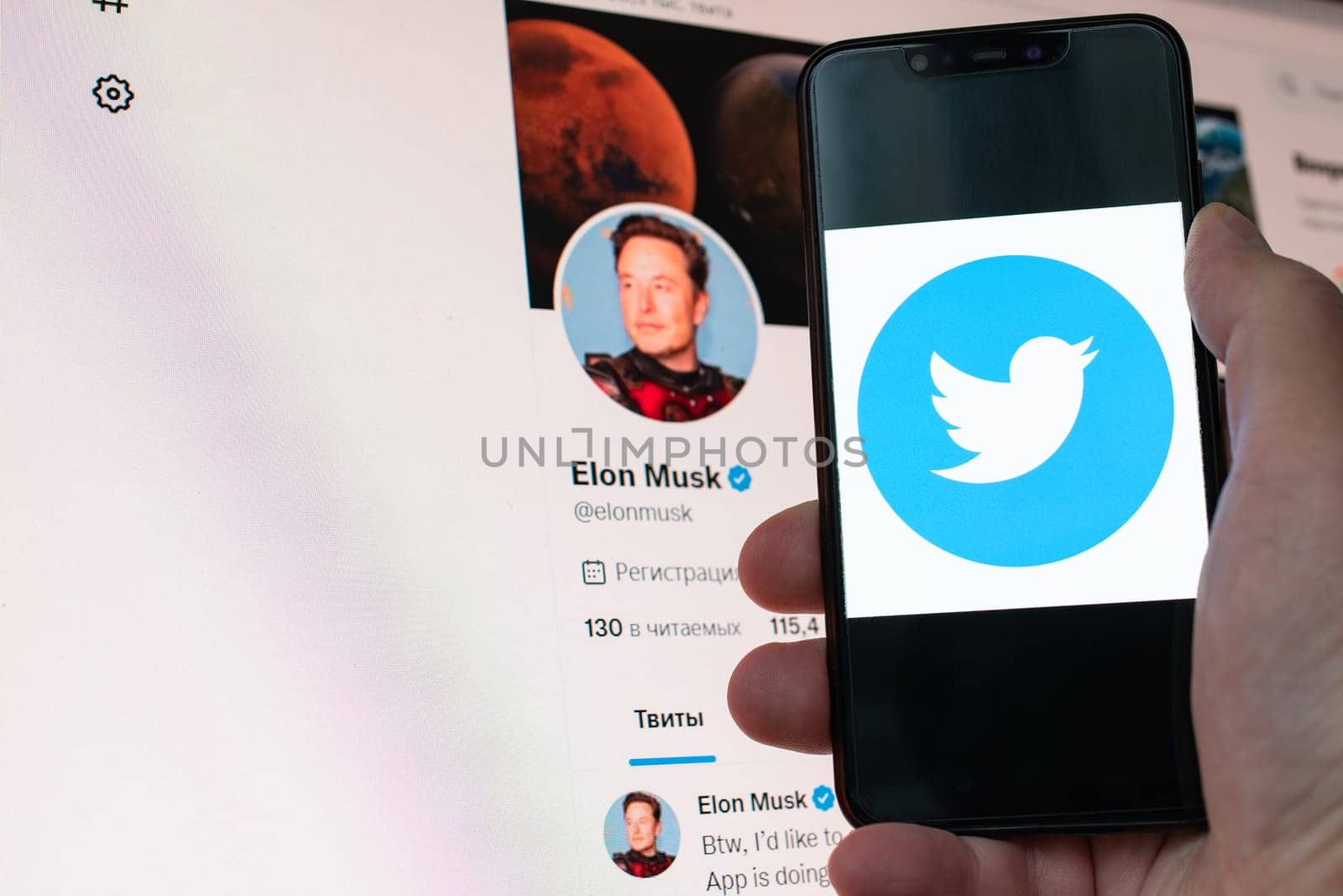 Kyiv, Ukraine - November 14, 2022: Elon Musk official Twitter profile on monitor and social media logo seen displayed on a smartphone close up in hand. Elon Musk reaches agreement to acquire Twitter