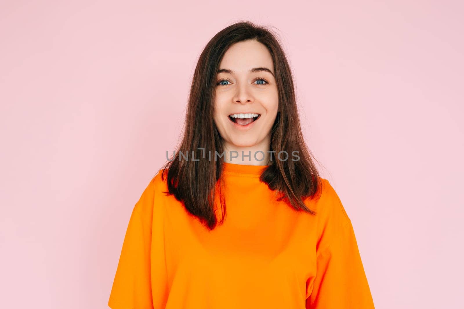 Surprised Delight: Cheerful Woman Expressing Amazement with Open Mouth - Joyful Reaction and Positive Energy on Vibrant Pink Background