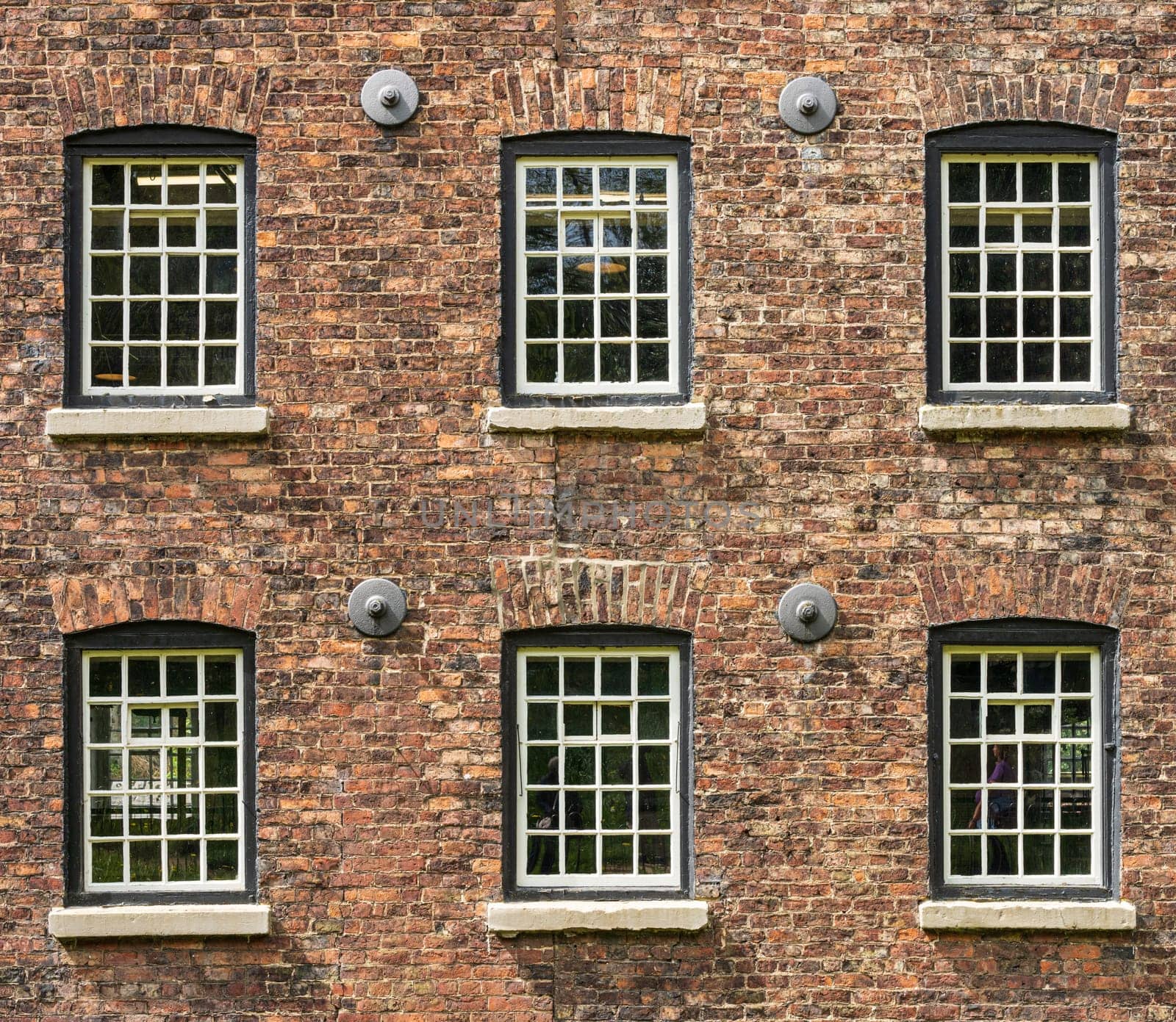 Exterior of restored cotton spinning and weaving mill in north of England with focus on windows