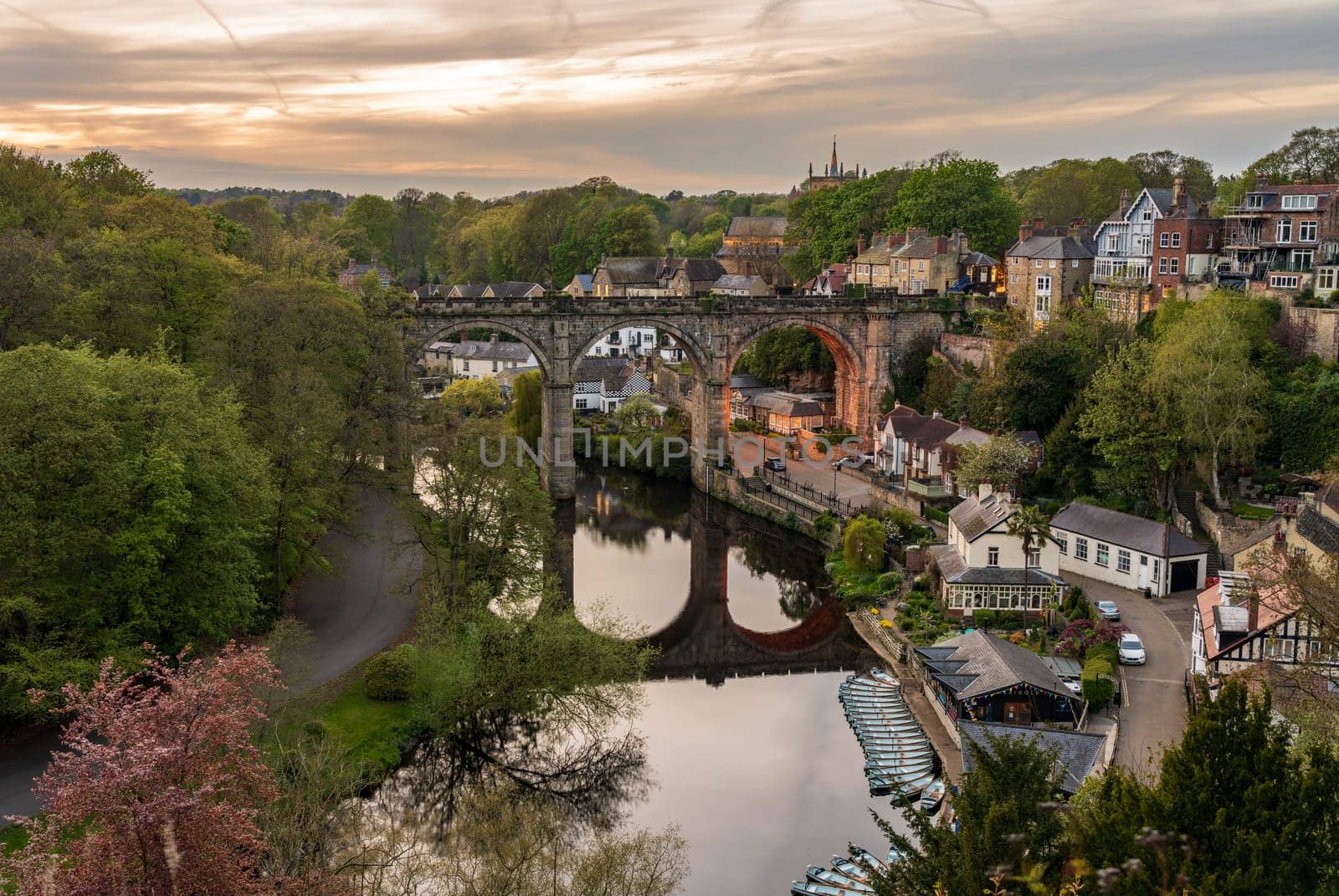 Stone viaduct over River Nidd at Knaresborough with rowing boats by riverbank