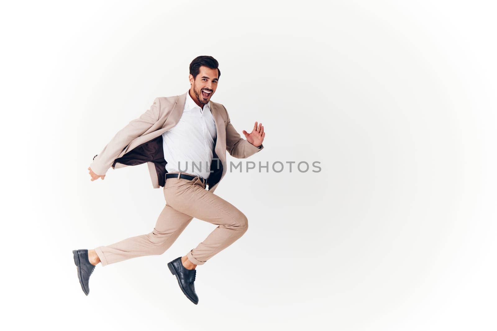 beige man businessman business happy winner victory running jumping suit smiling by SHOTPRIME