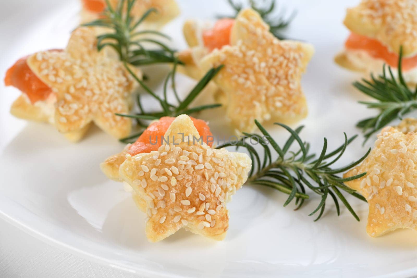 Festive appetizer of puff pastry in the shape of a star, stuffed with salmon and soft cheese. The perfect appetizer for your holiday table.