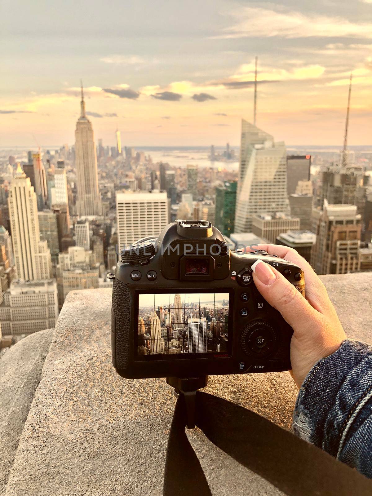 Female Hand With camera taking picture of new york city skyline on a rooftop
