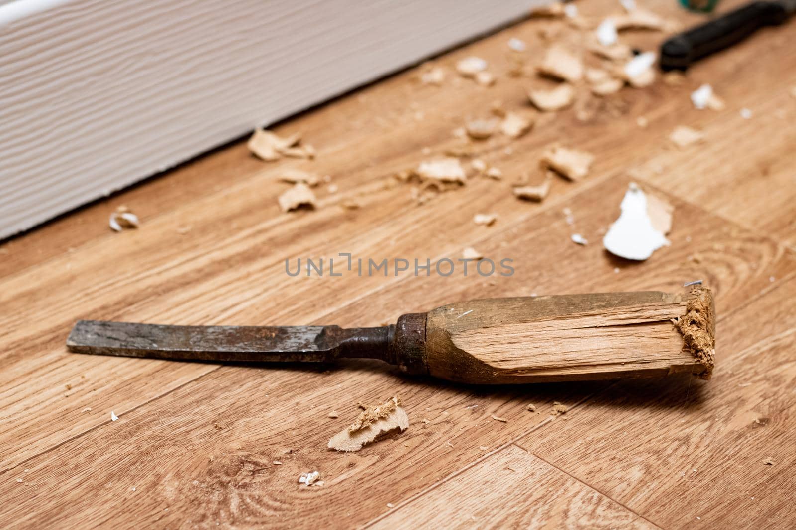 Chisel among sawdust on a wooden floor close up