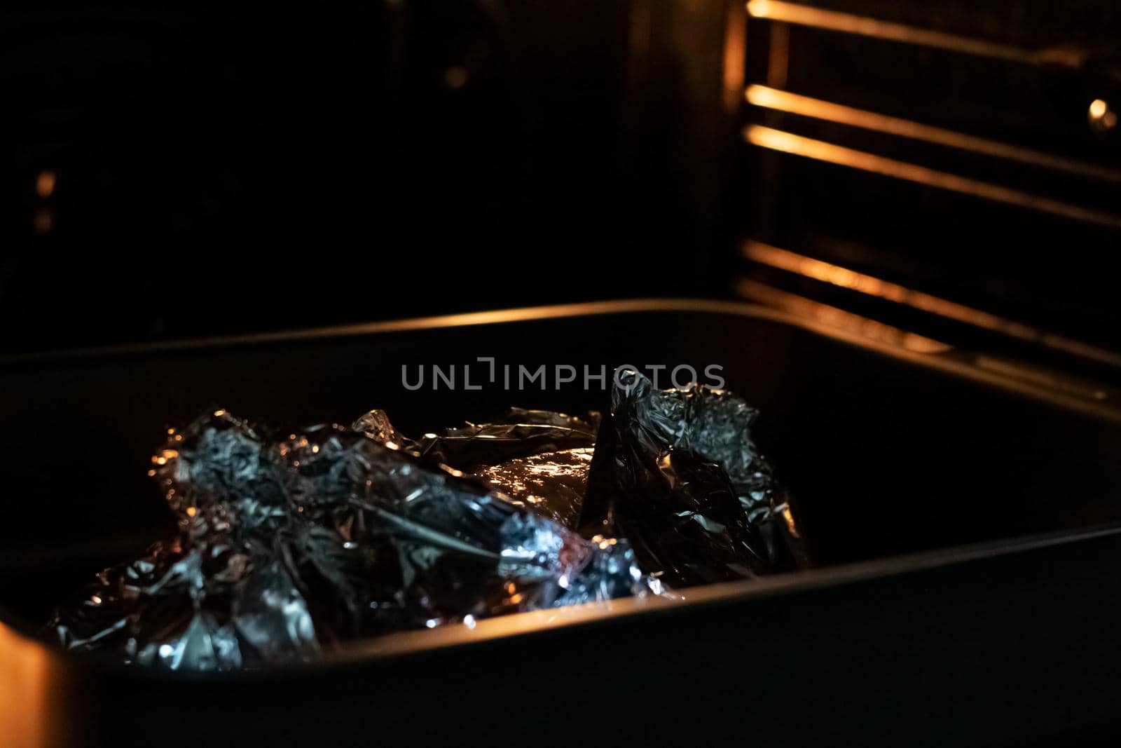 Oven in foil in a baking sheet in dark