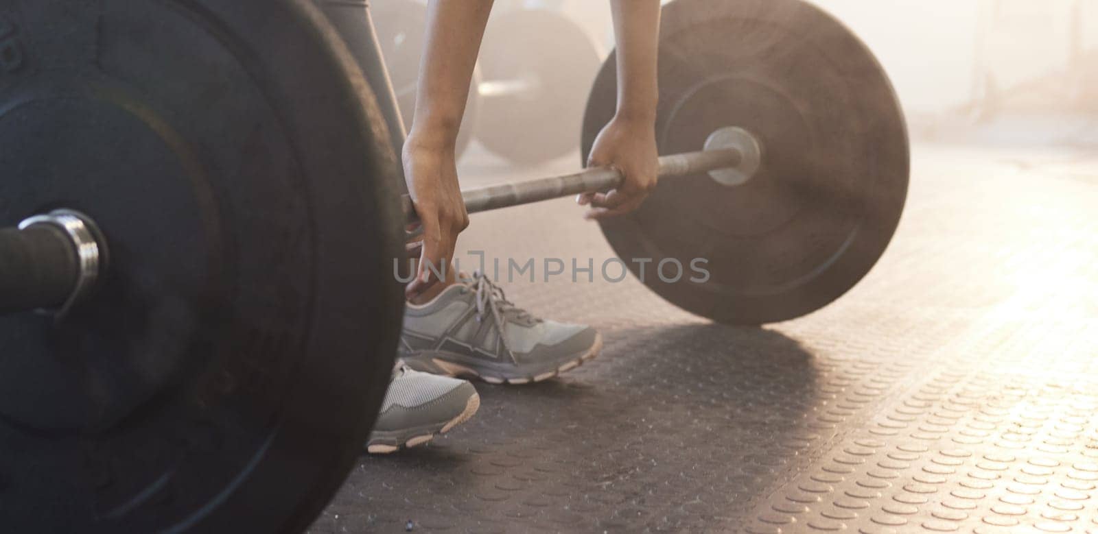 Fitness, woman in gym and barbell for weightlifting, power and muscle with closeup on equipment at sports club. Balance, strength and female bodybuilder lifting weights and training with health goals.