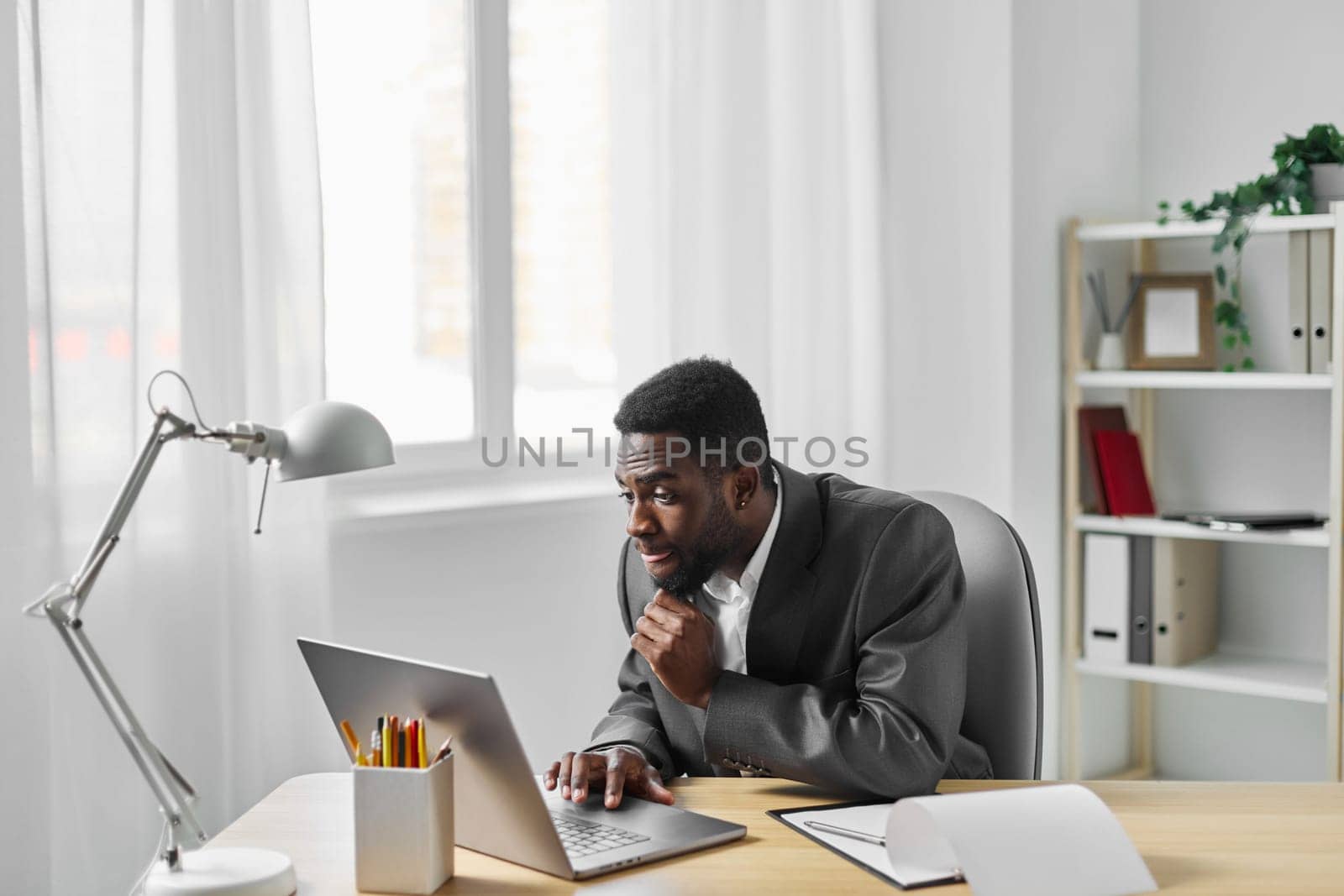 american man student using freelancer computer education online job laptop african office by SHOTPRIME