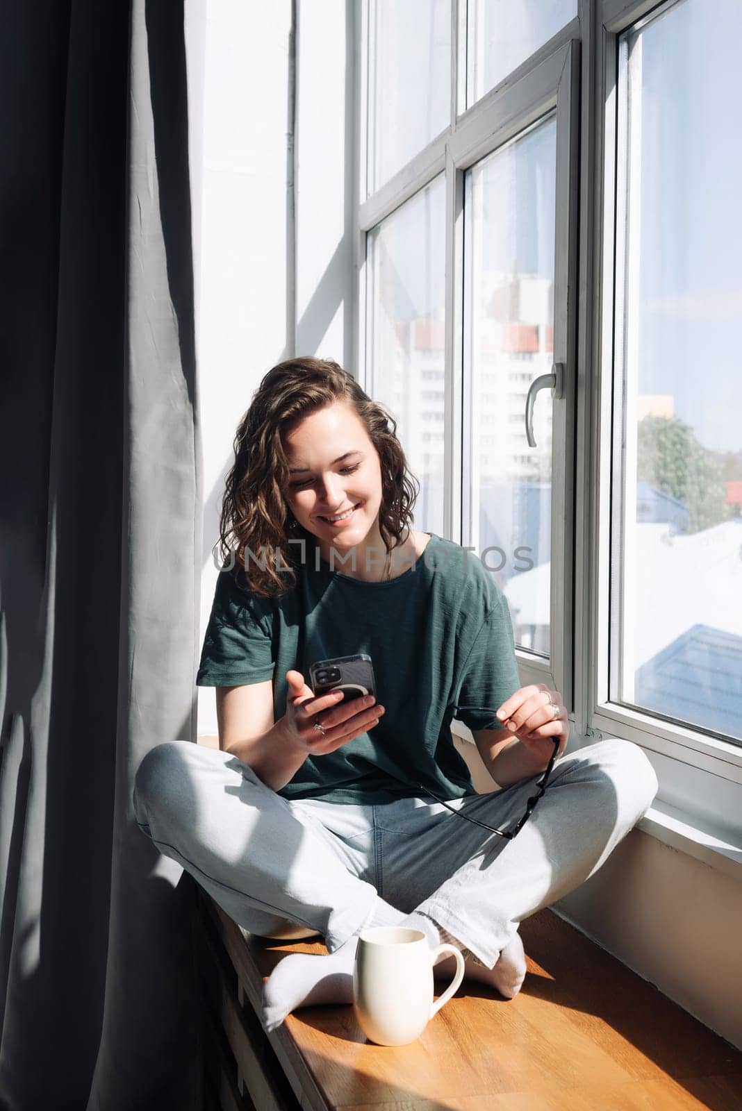 Connected and Productive: Woman Engaged in Smartphone Communication at Home - Student Balancing Work, Study, and Lifestyle through Mobile Apps and Technology.