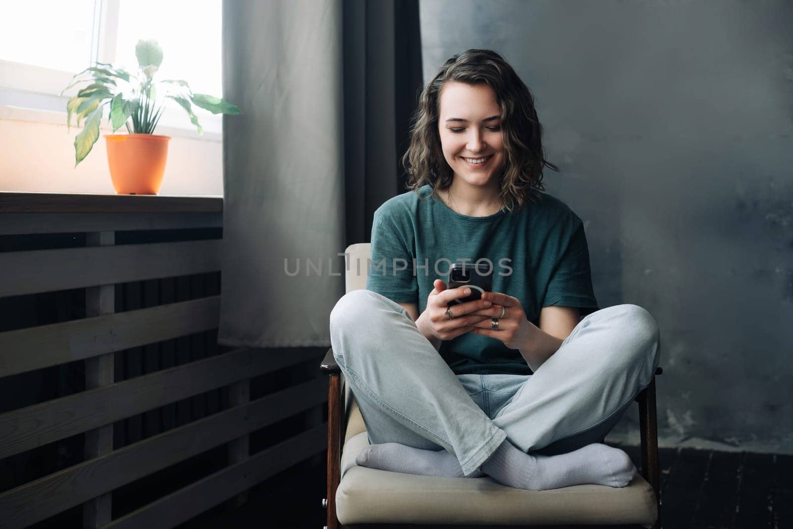 Digital Lifestyle: Young Woman Engages in Communication and Productivity Through Smartphone in the Comfort of Home. A Blend of Study, Work, and Connection in the Digital Age.