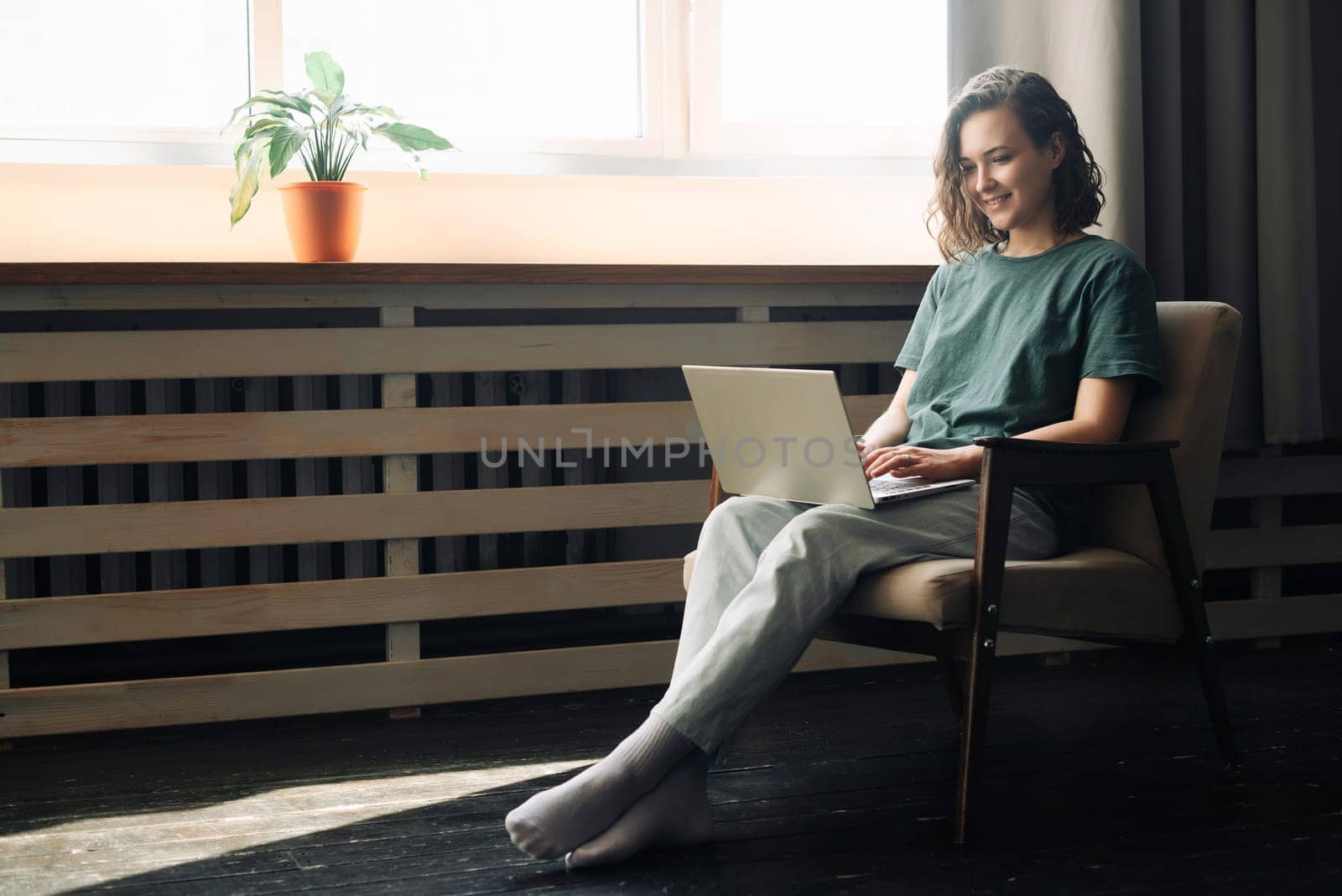 Efficiency and Flexibility: Young Woman Embraces Remote Work and Study, Utilizing Laptop at Home. Versatile Lifestyle of Freelancing, Business, and Self-Determination in a Cozy Home Environment