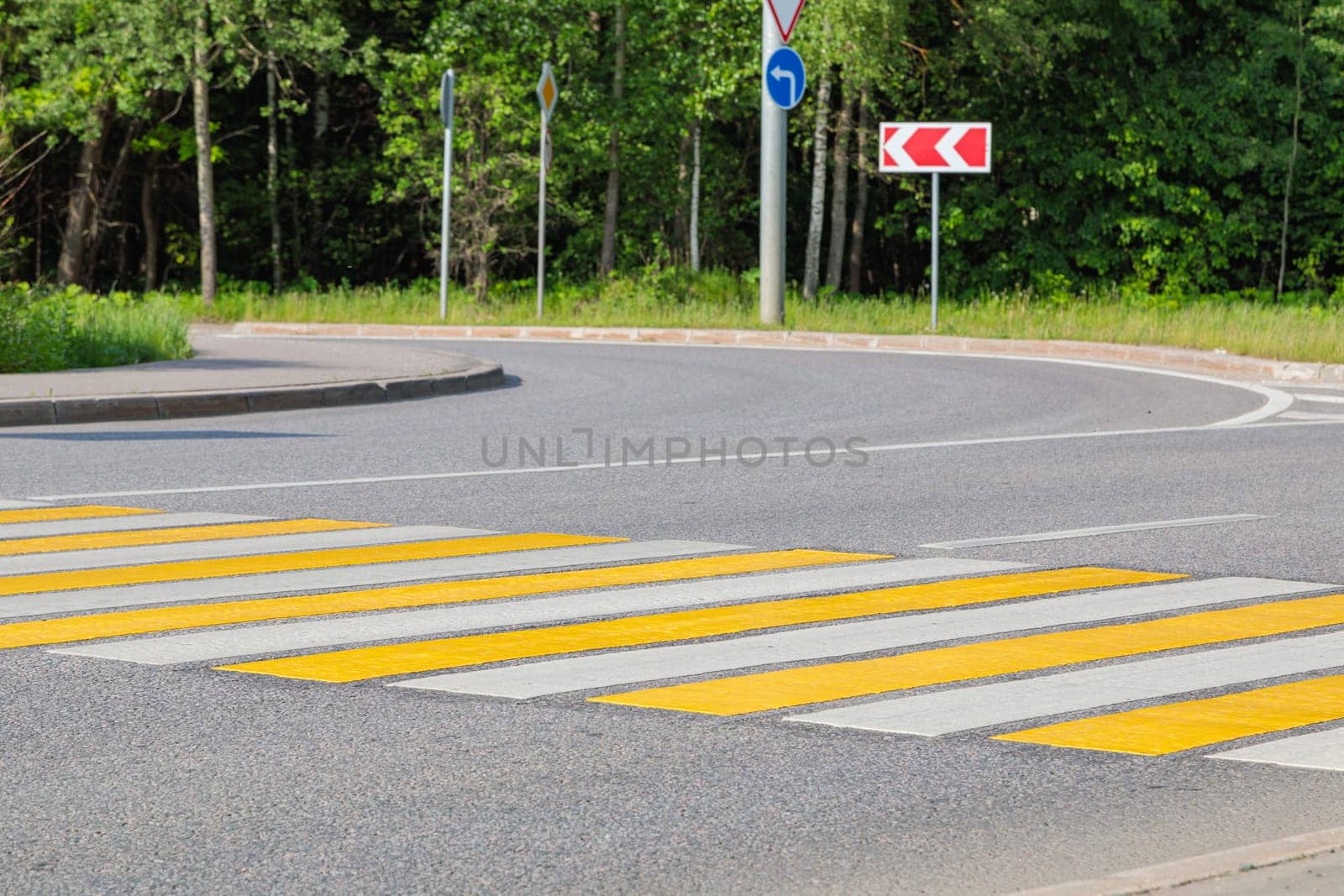 Pedestrian crossing with yellow and white stripes. High quality photo